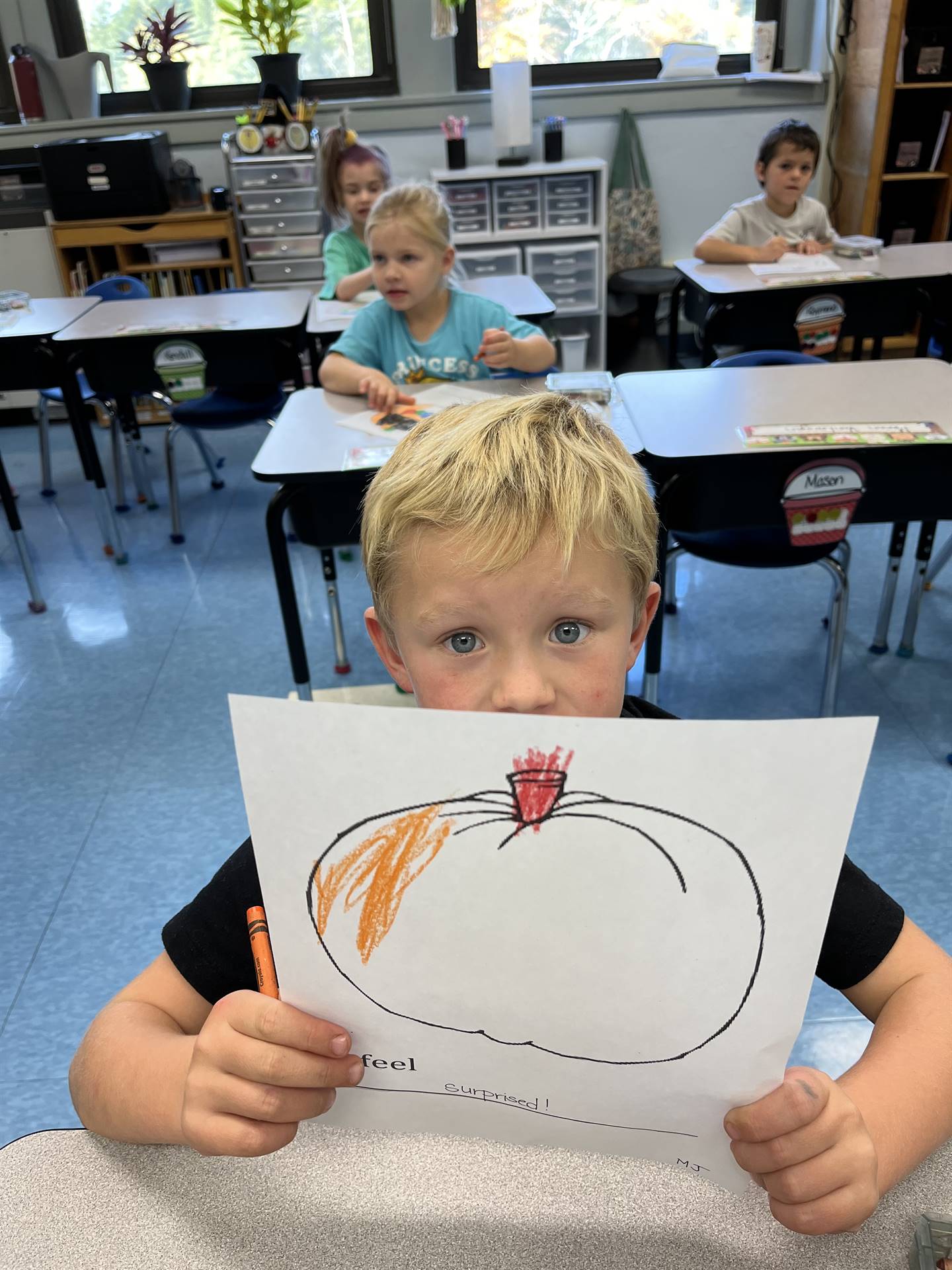 student holding a colored pumpkin