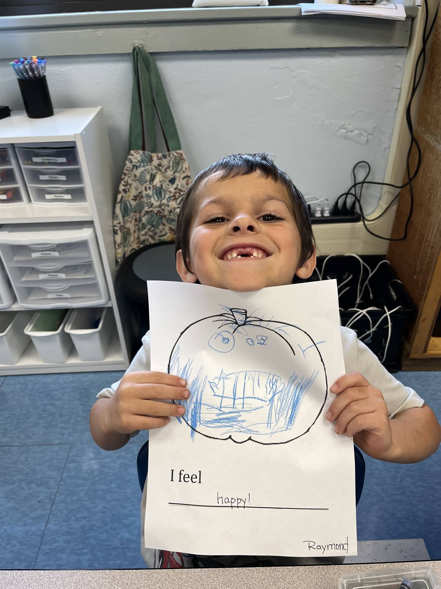 student holding a blue colored pumpkin