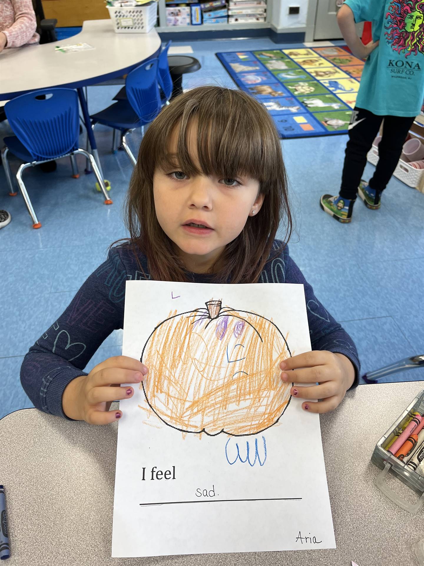 student with a paper pumpkin with a sad emotion