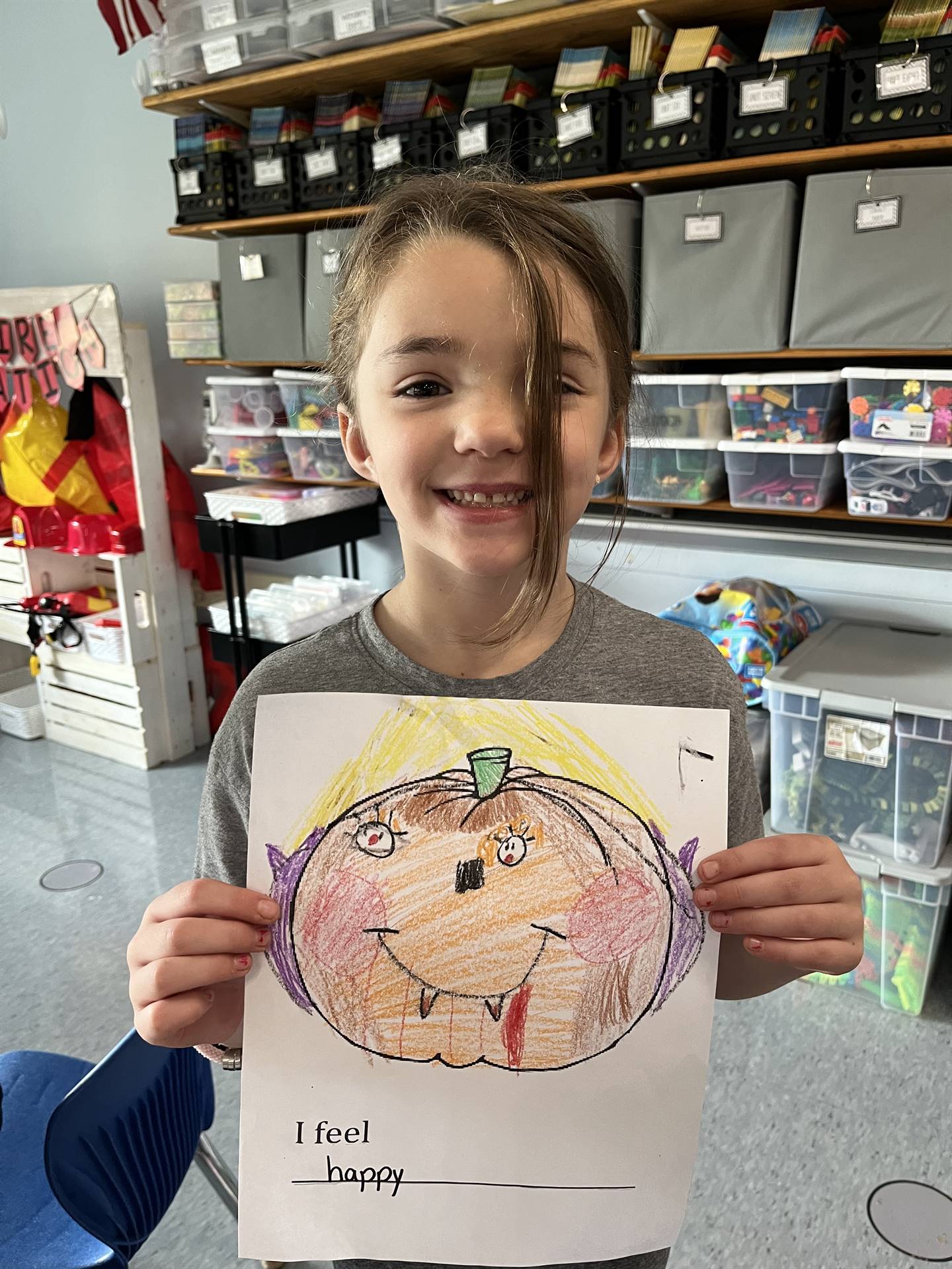 student with a paper pumpkin with a happy emotion
