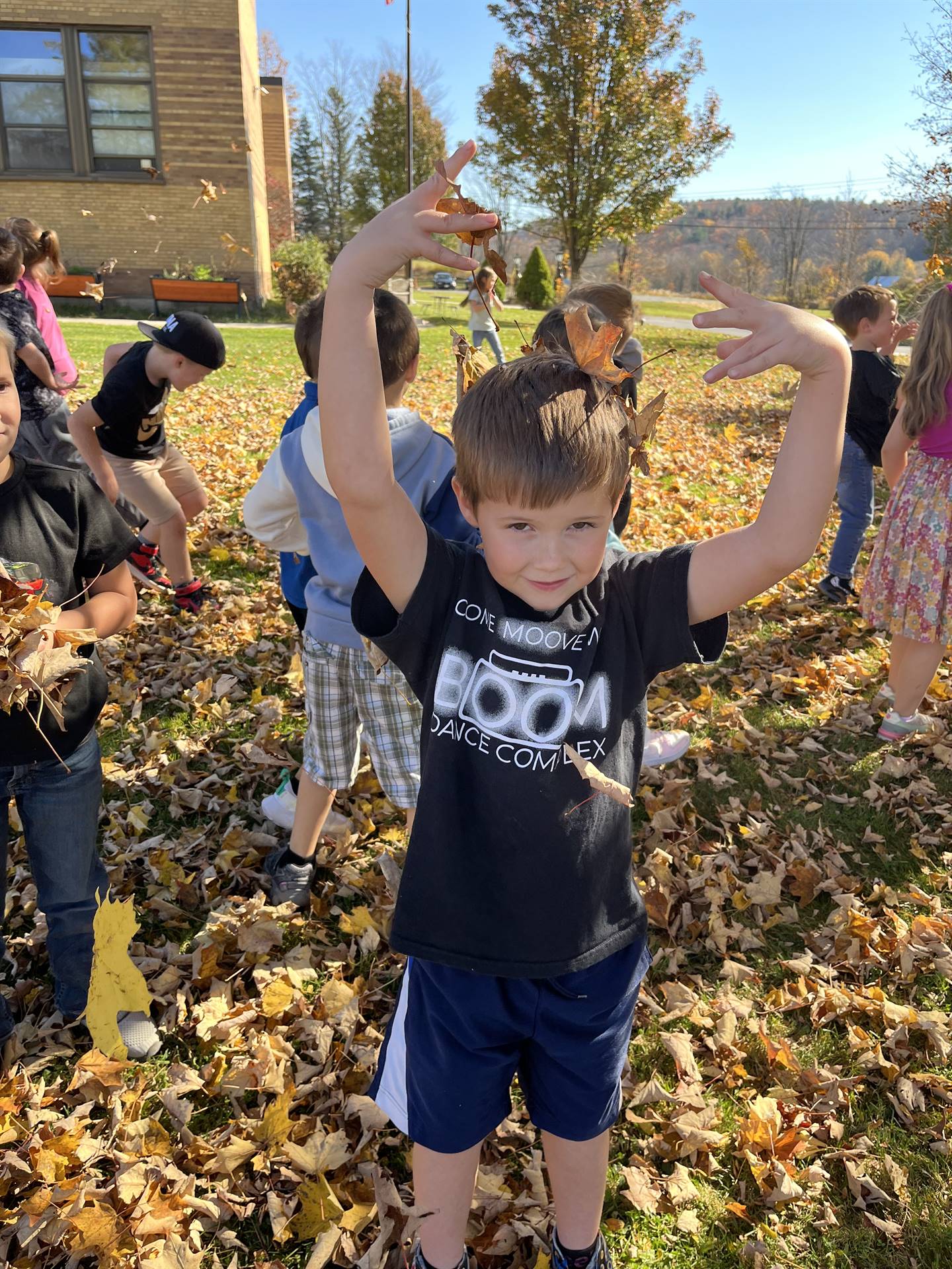 a kids with leaves on his head.