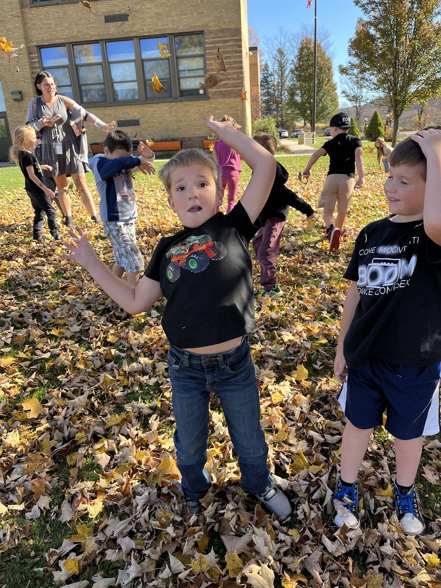 kids outdoors playing with leaves