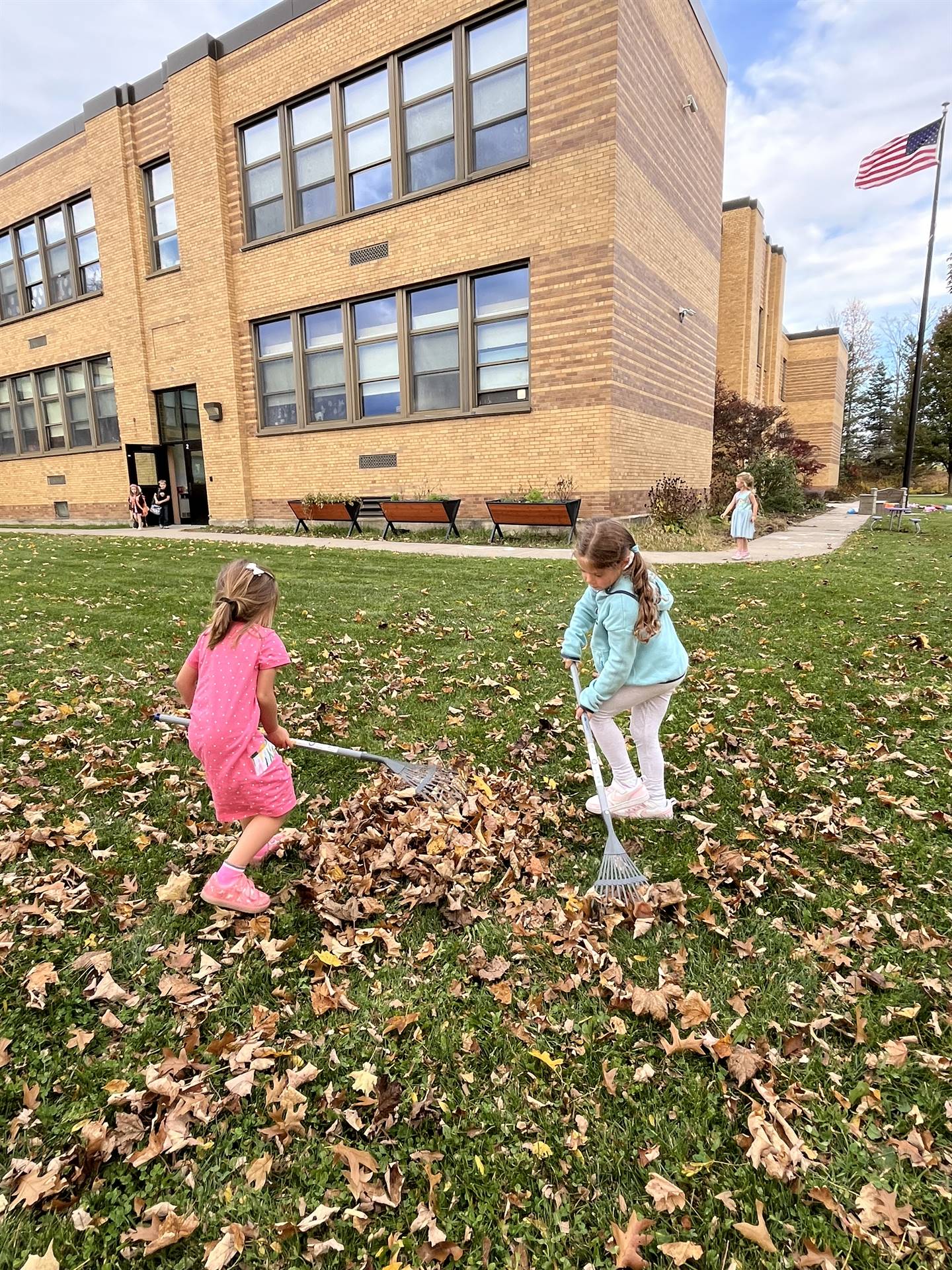 2 students raking leaves