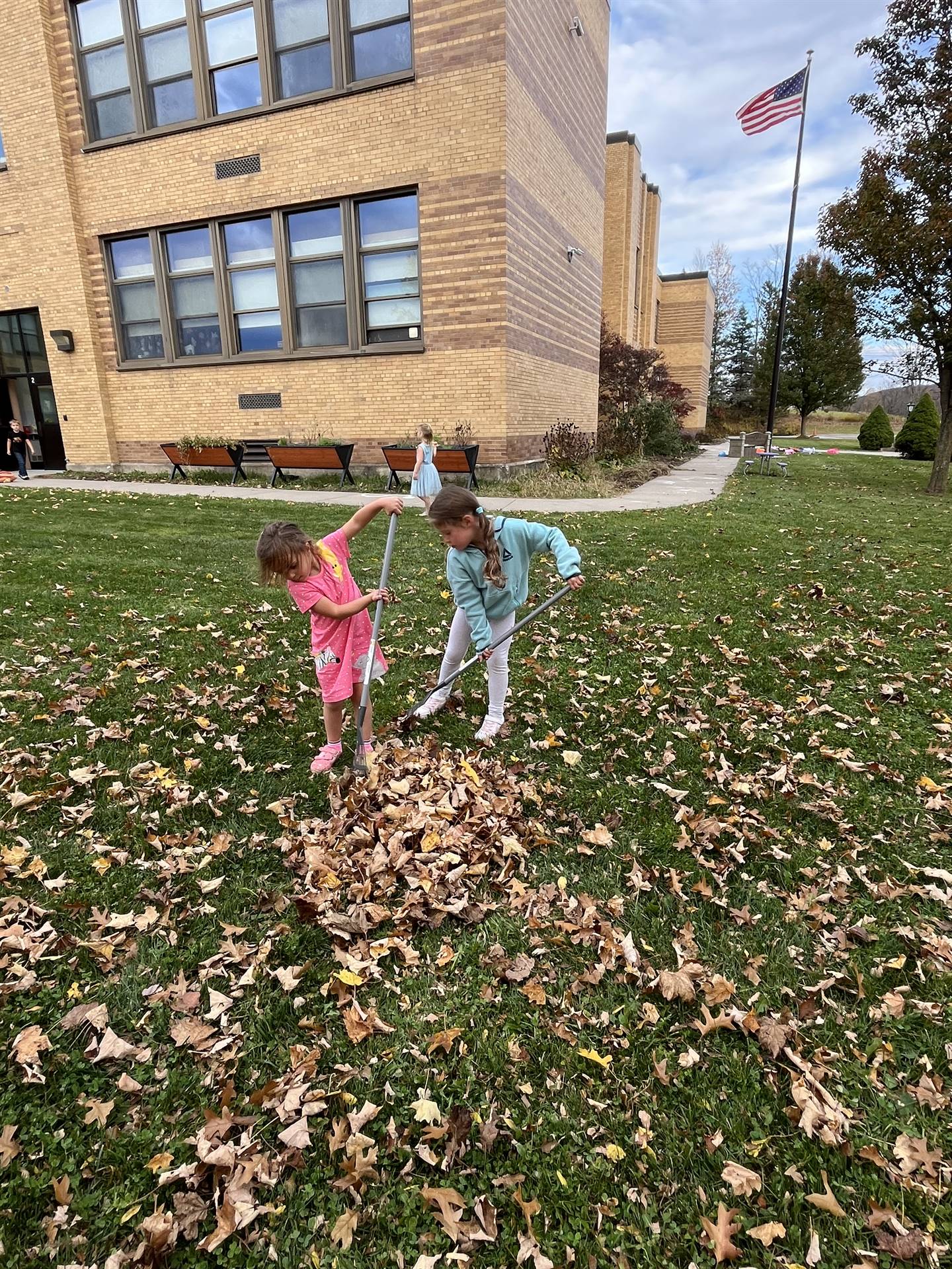 2 students raking leaves