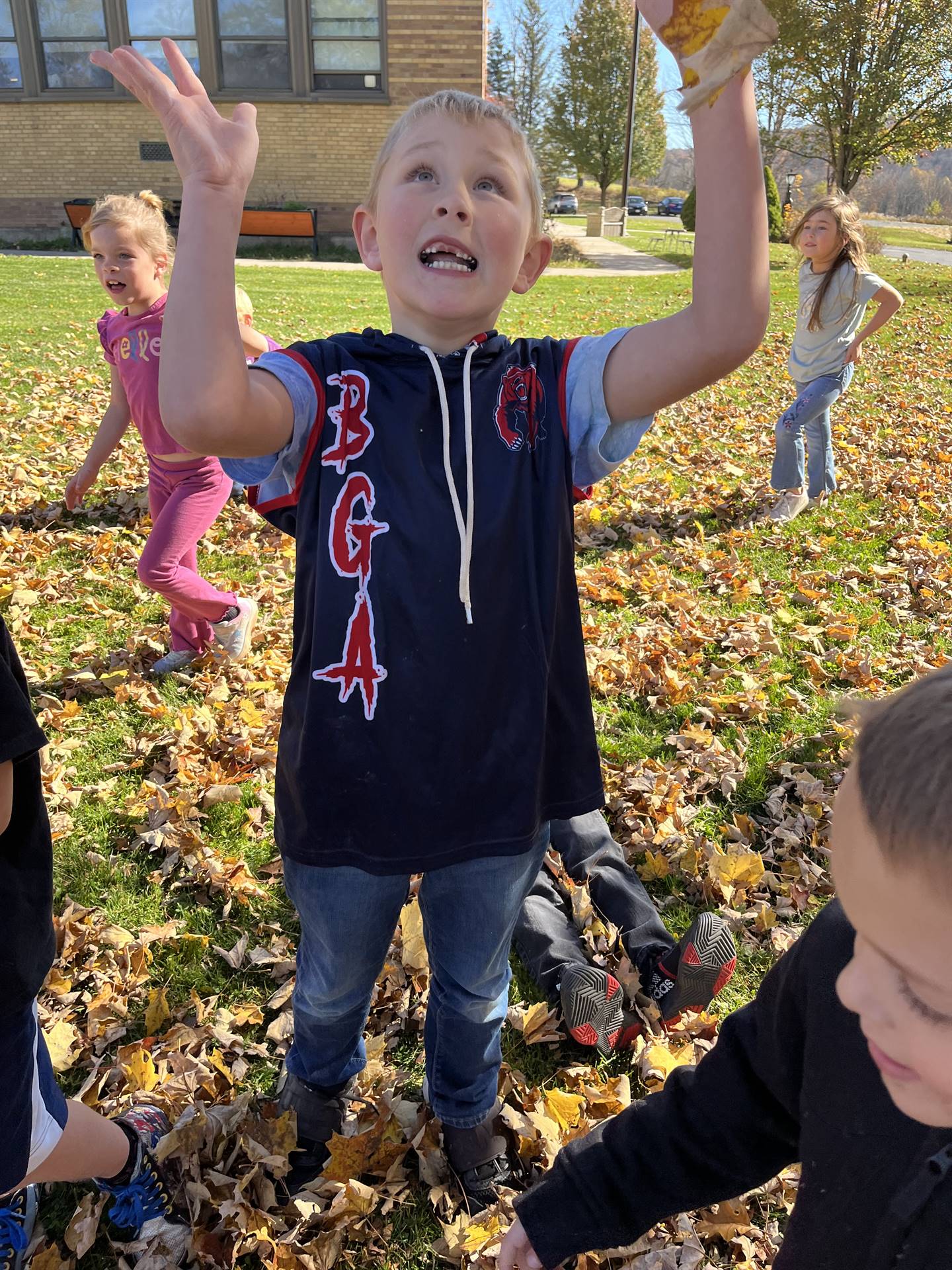 a kid throwing leaves in air.