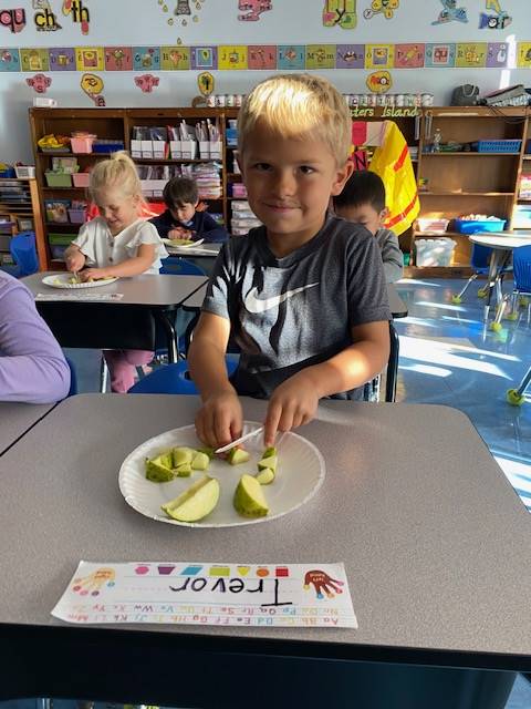 student cutting up an apple 