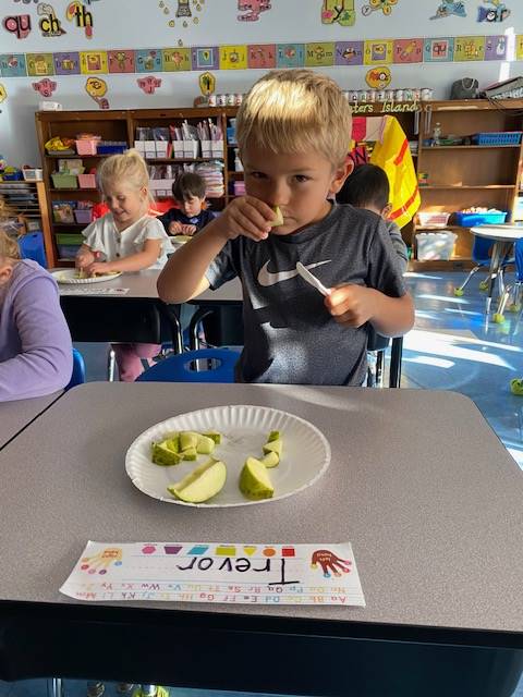 student smelling an apple