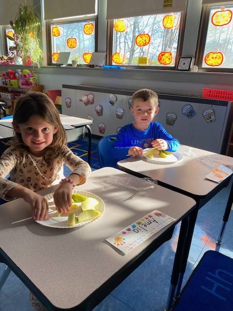 students cutting up apples