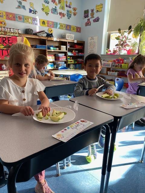 students cutting up apples
