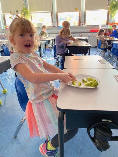 student cutting up apples
