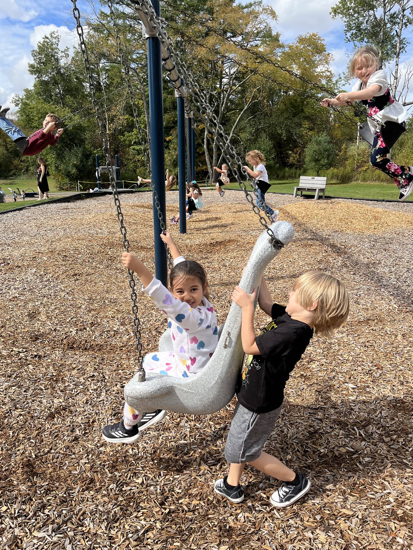 student pushing another on a swing