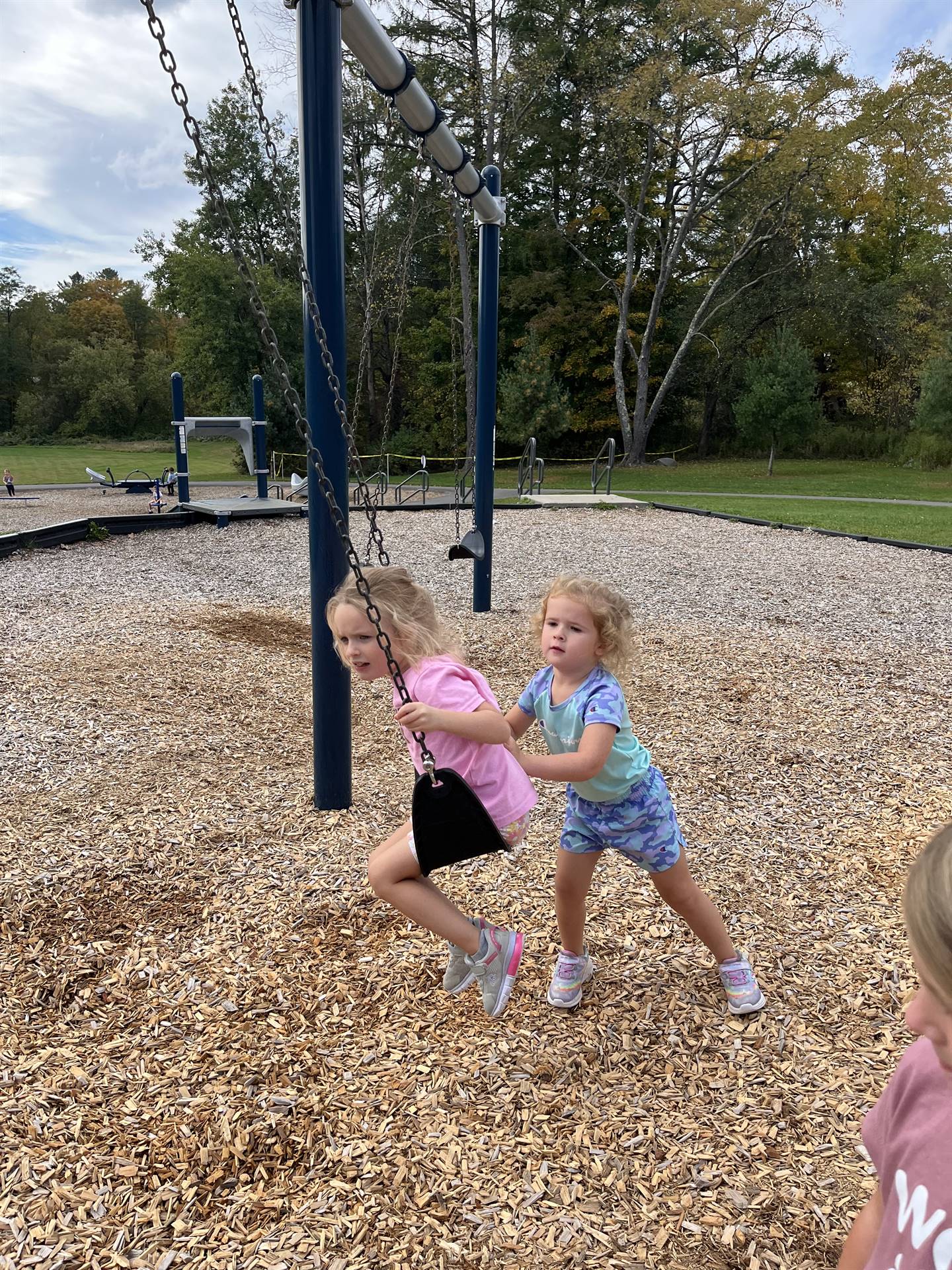 student pushing another on a swing