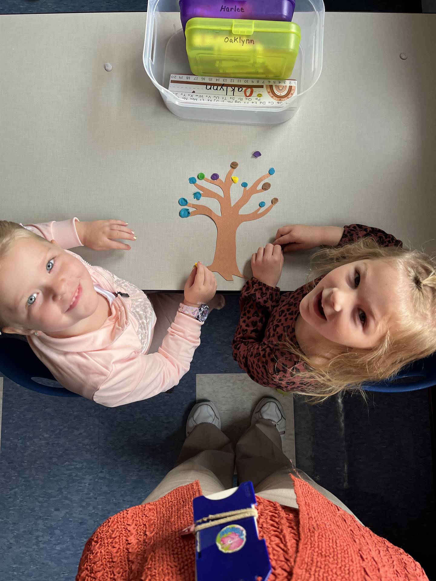 2 students using play do to create leaves for a bare fall tree