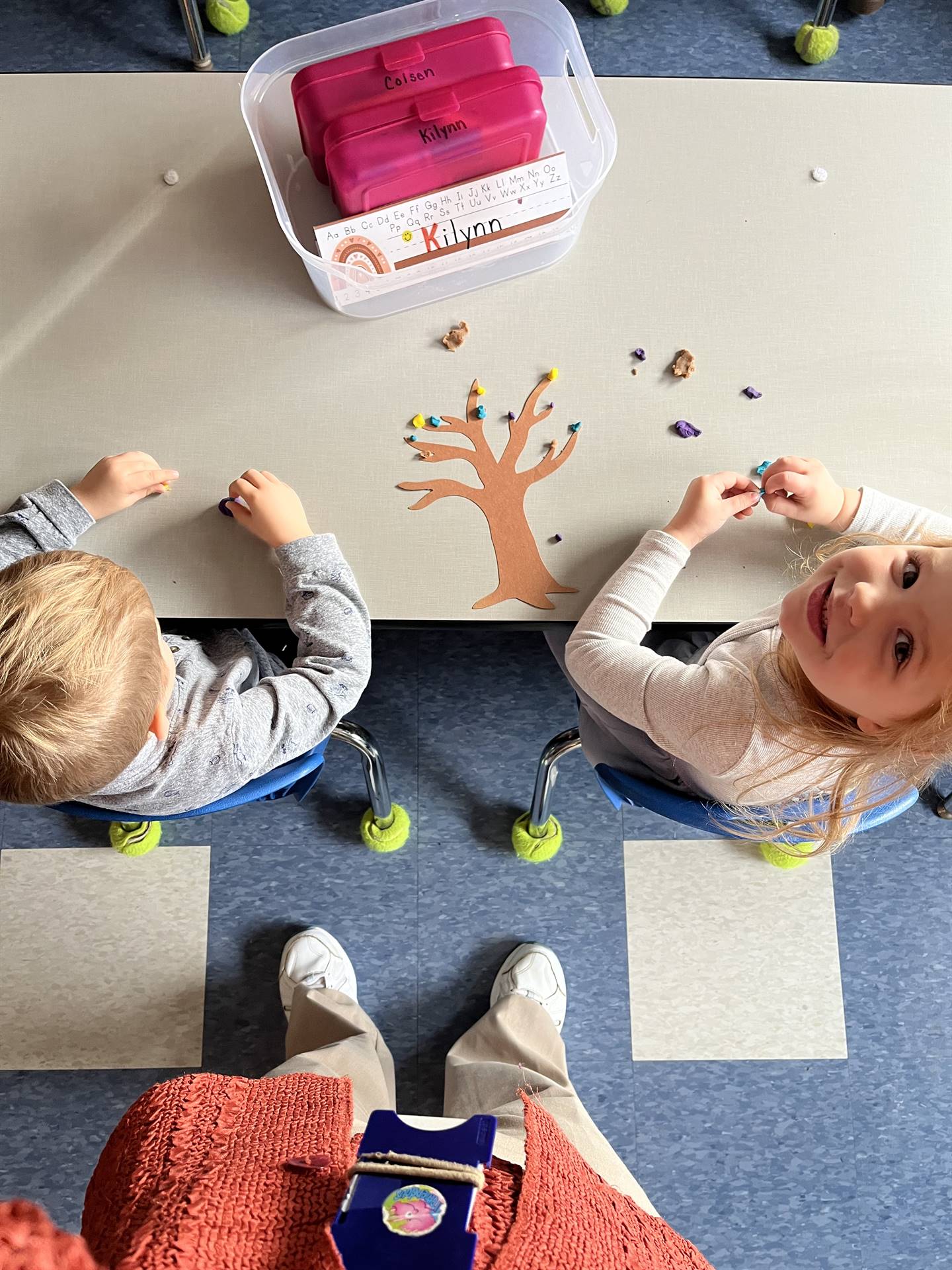 2 students using play do to create leaves for a bare fall tree