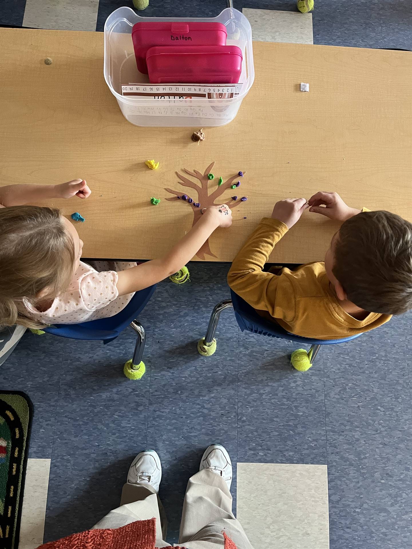 2 students using play do to create leaves for a bare fall tree