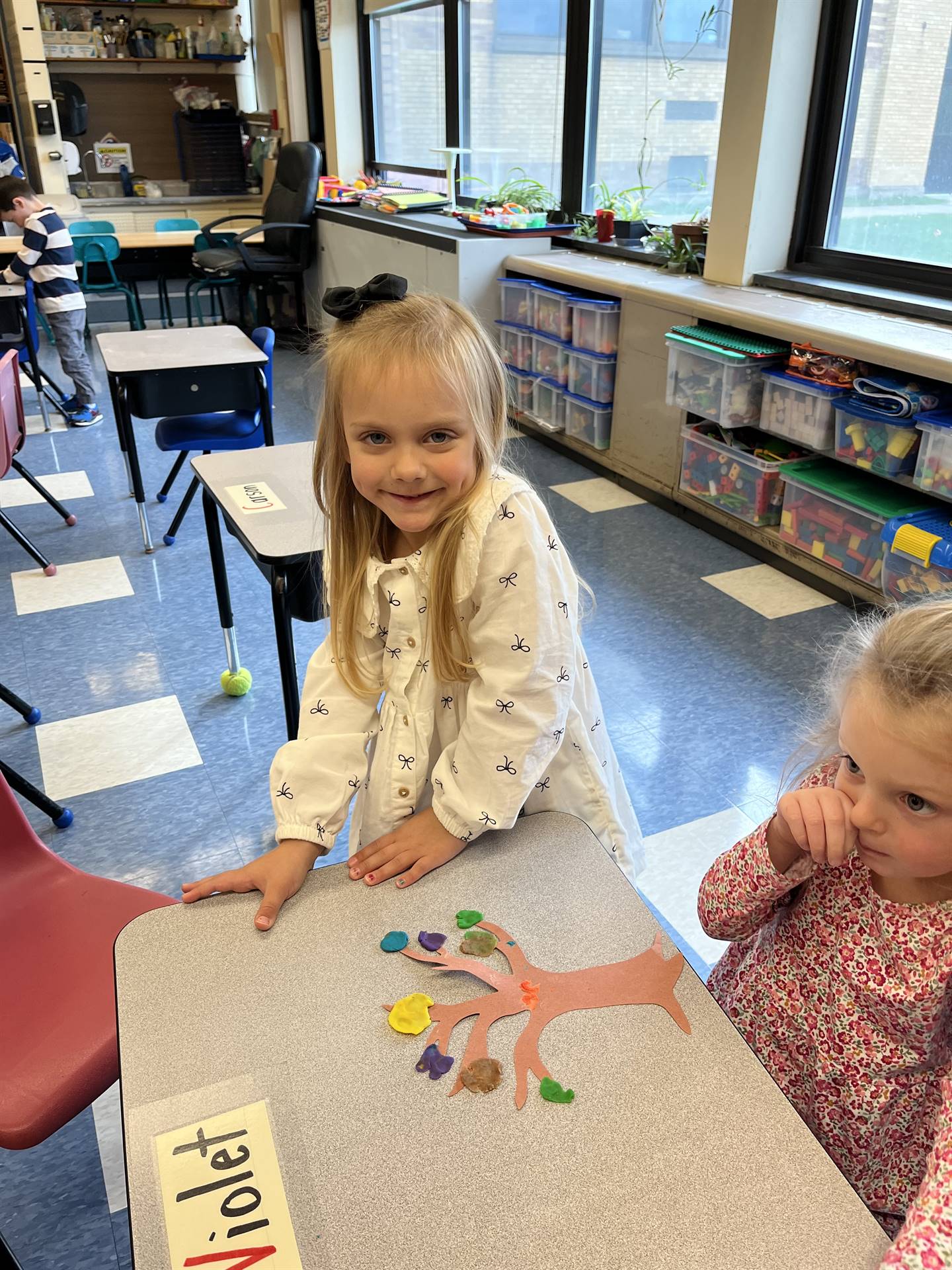 2 students using play do to create leaves for a bare fall tree
