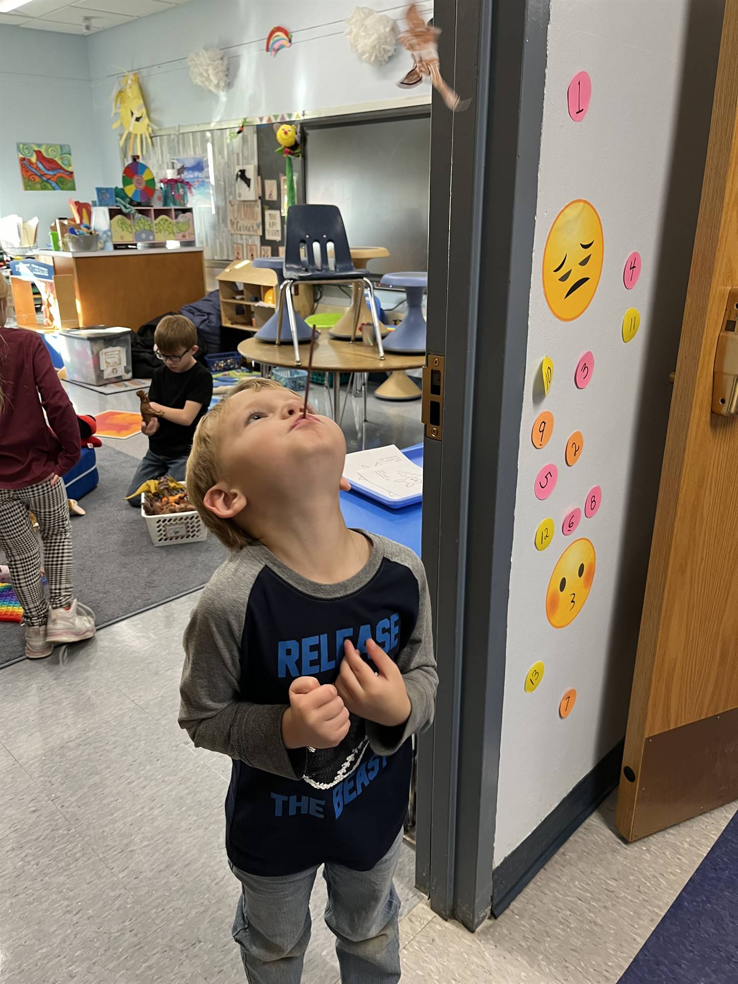 student blowing a paper bat in the air.