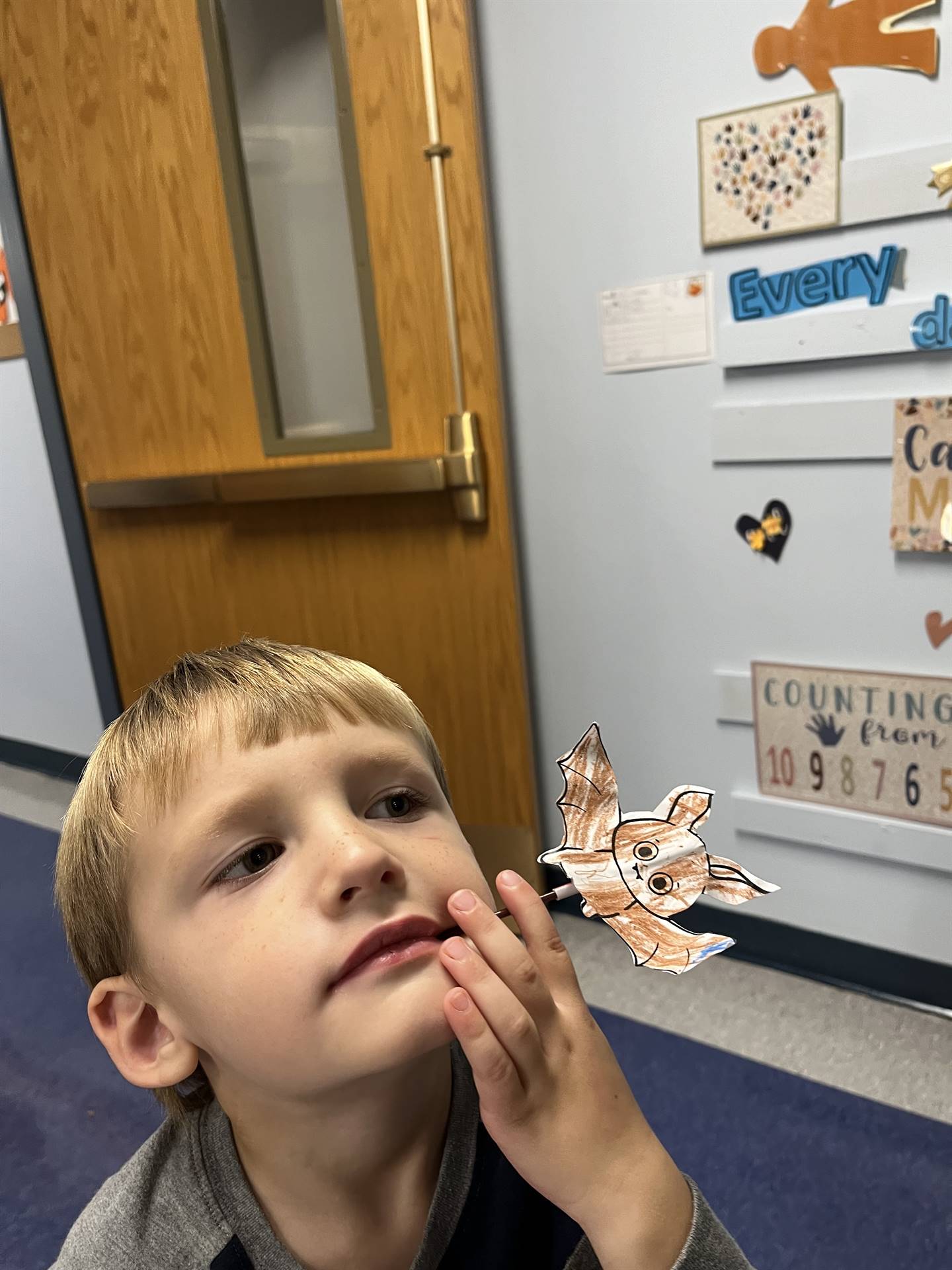 student getting ready to blow a paper bat in the air.