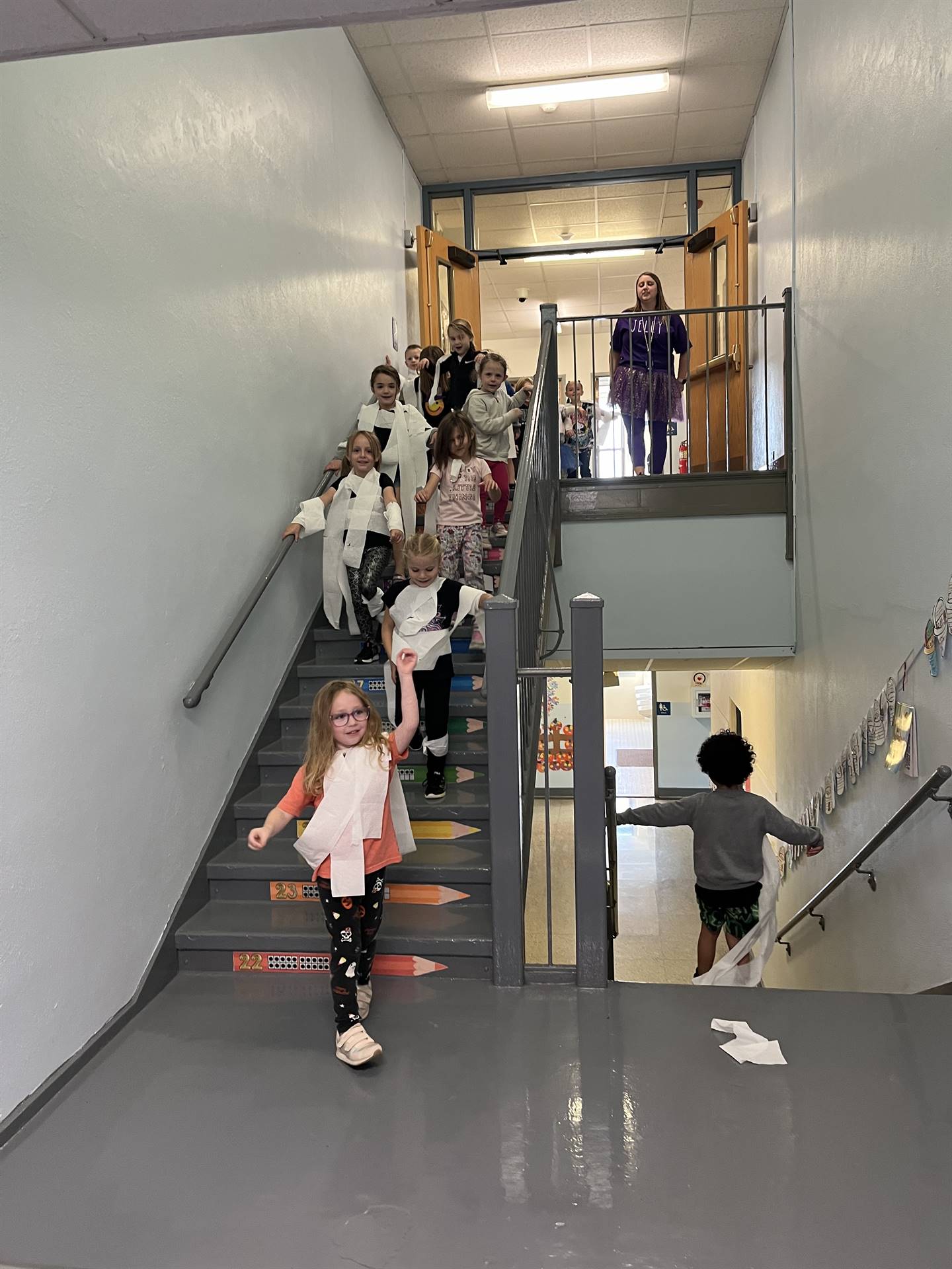 kids wrapped in toilet paper descending stairs
