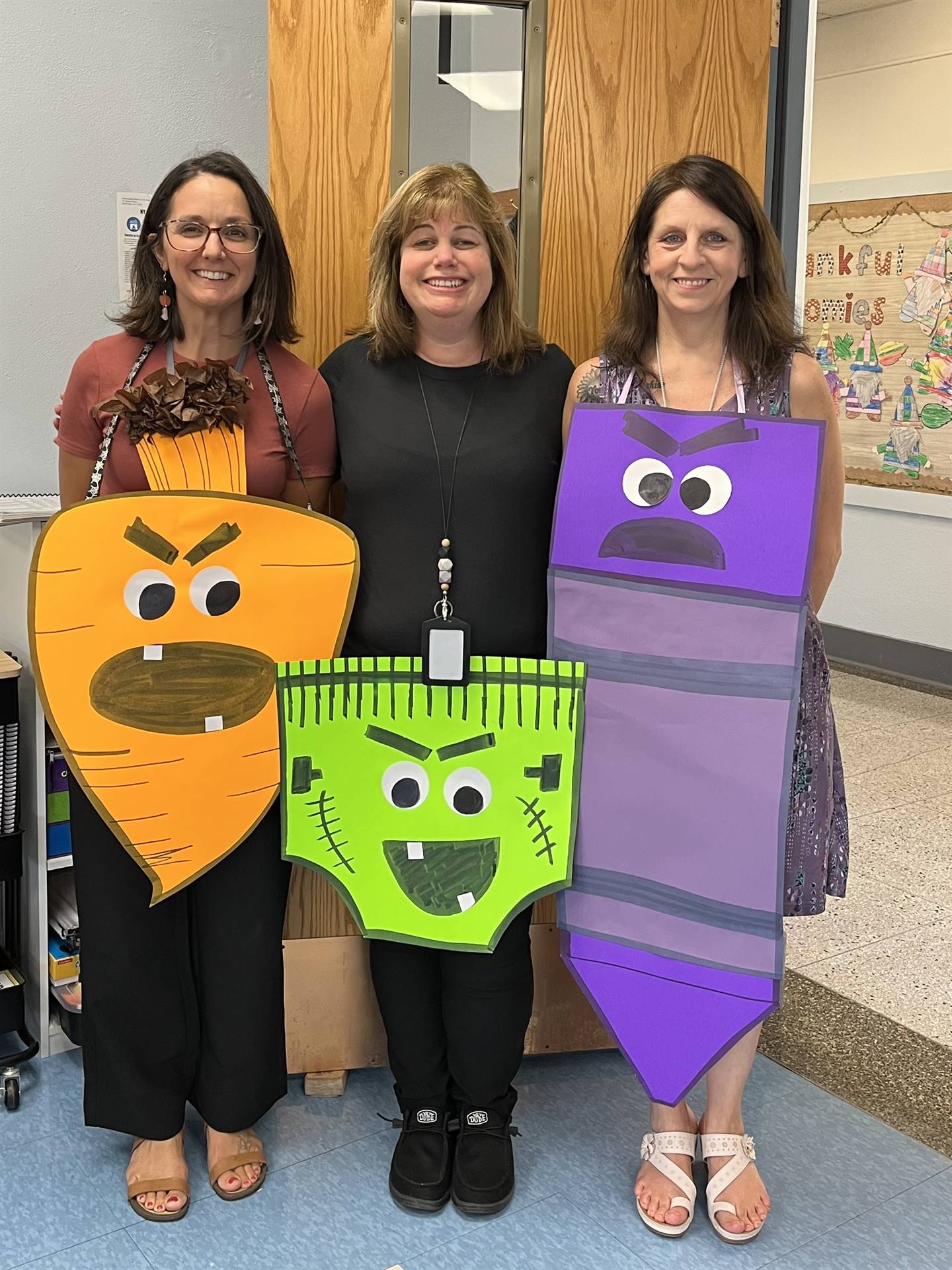 3 adults dressed as carrot, green scary underwear, and grumpy pencil