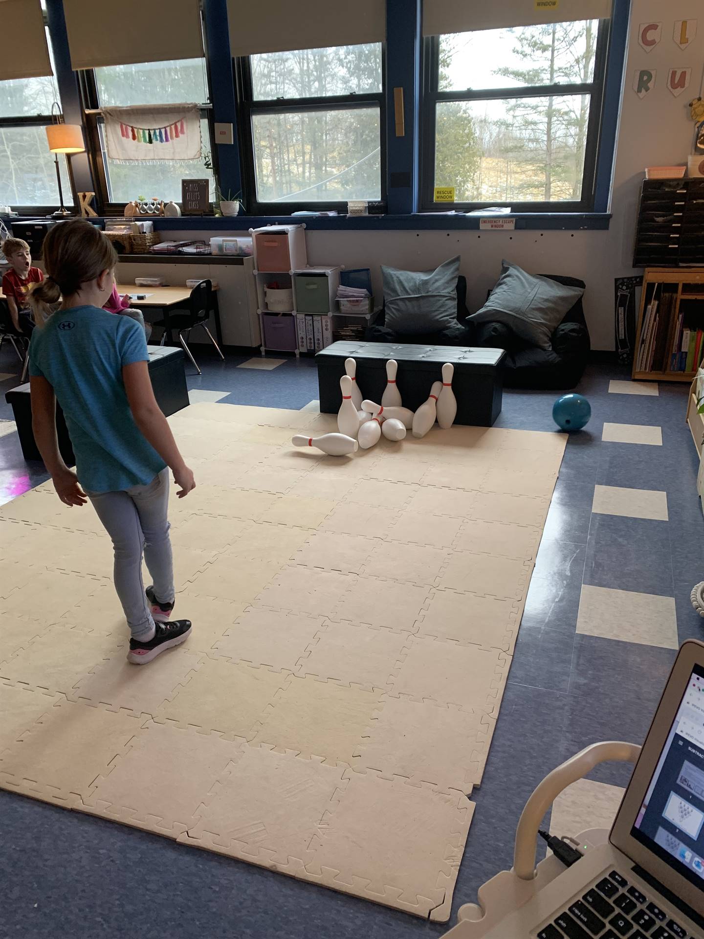 students on a mat with bowling pins