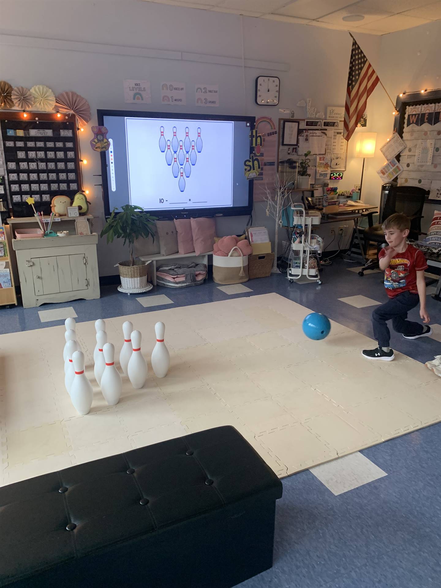 a student throws a bowling ball at the pins.