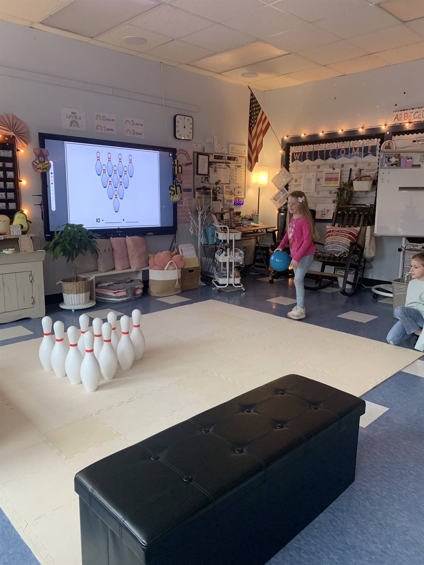 a student throws a bowling ball at the pins.