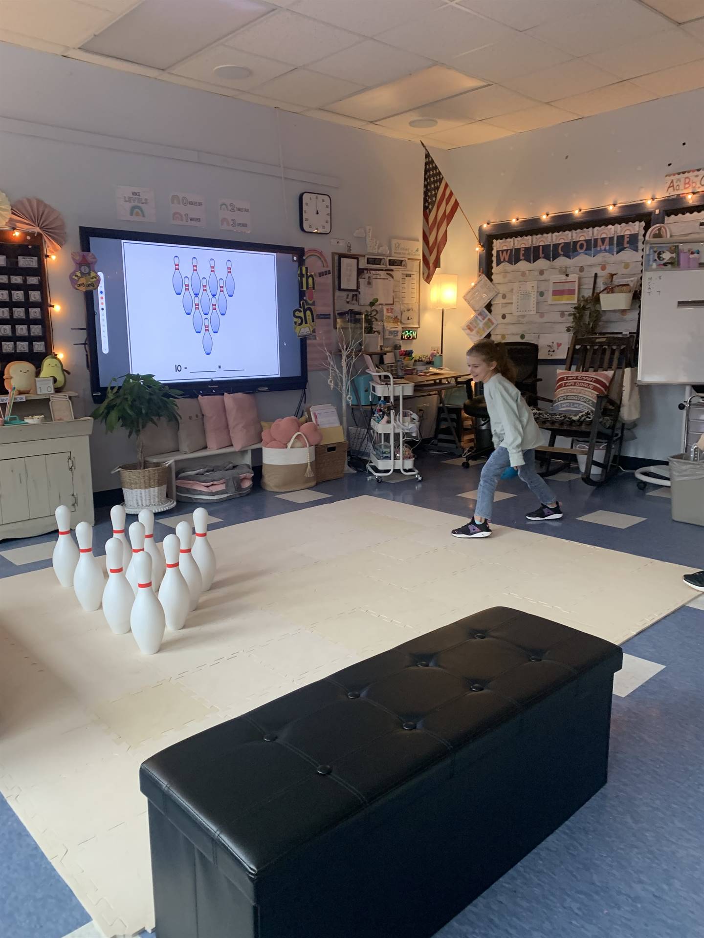 a student throws a bowling ball at the pins.