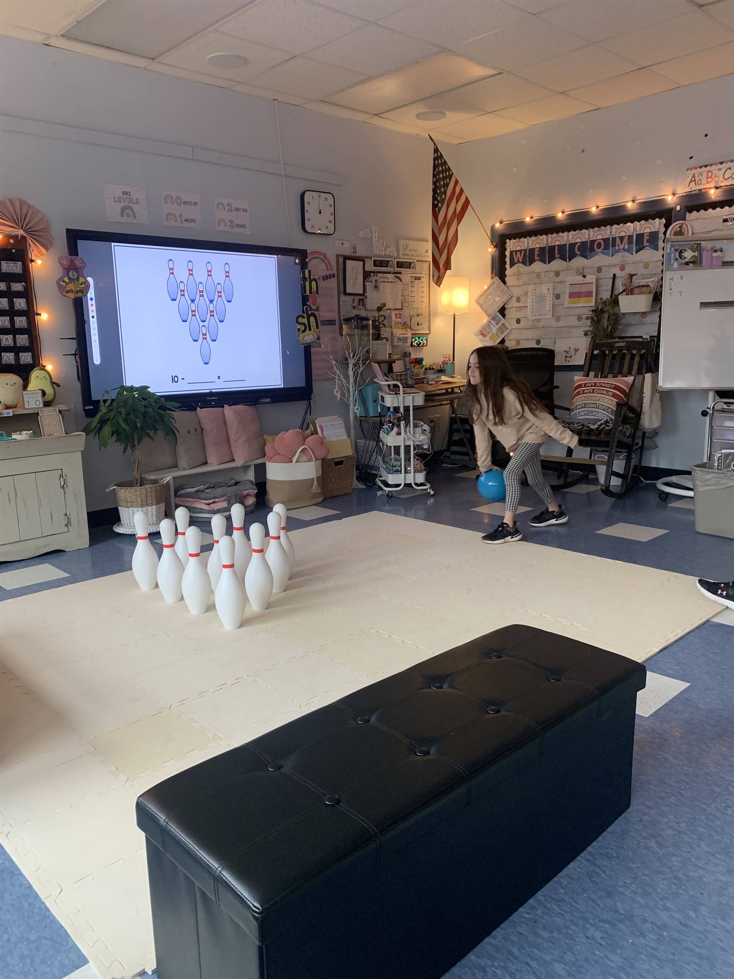 a student throws a bowling ball at the pins.