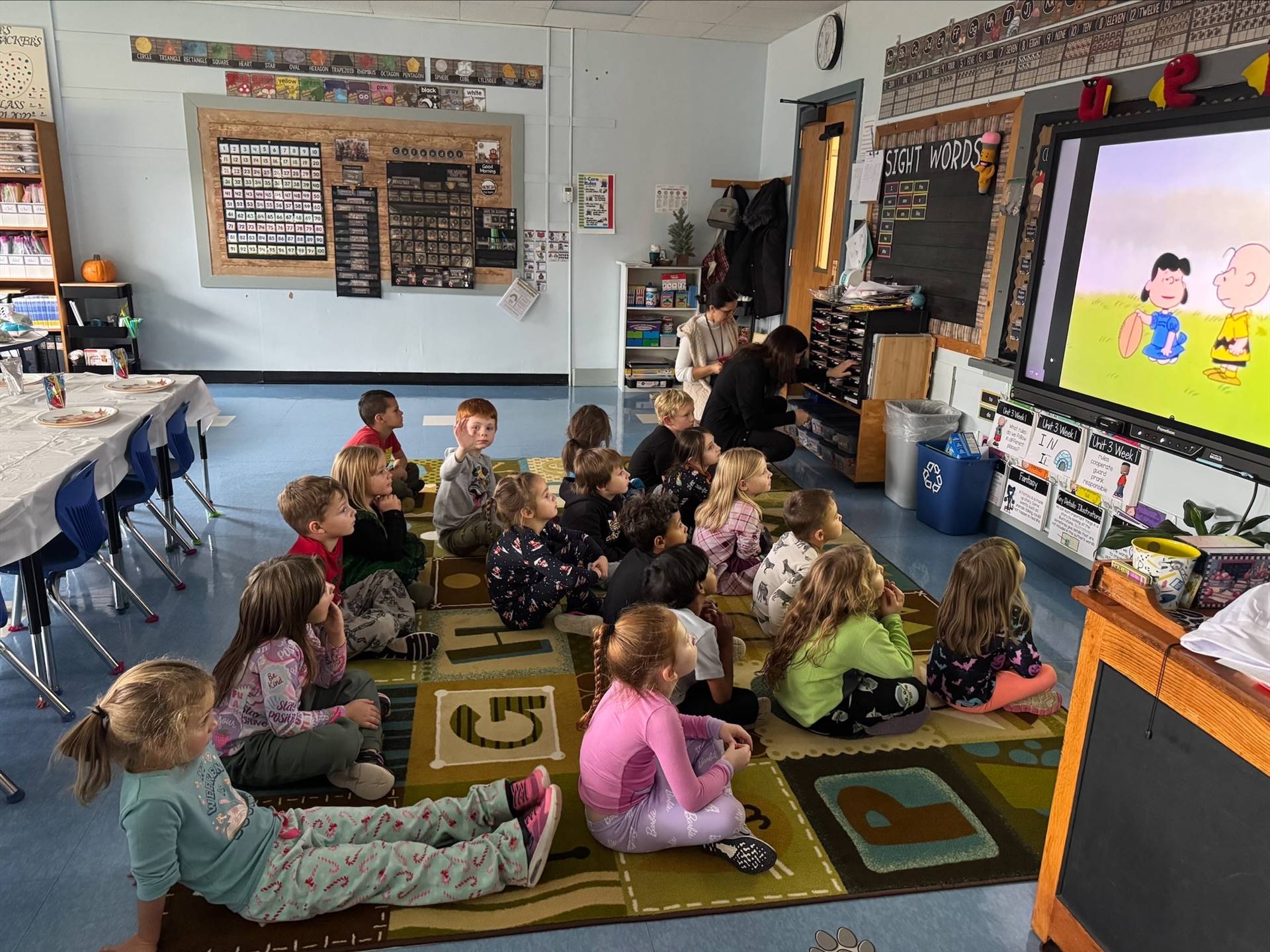 students sitting on floor watching Charlie Brown Thanksgiving
