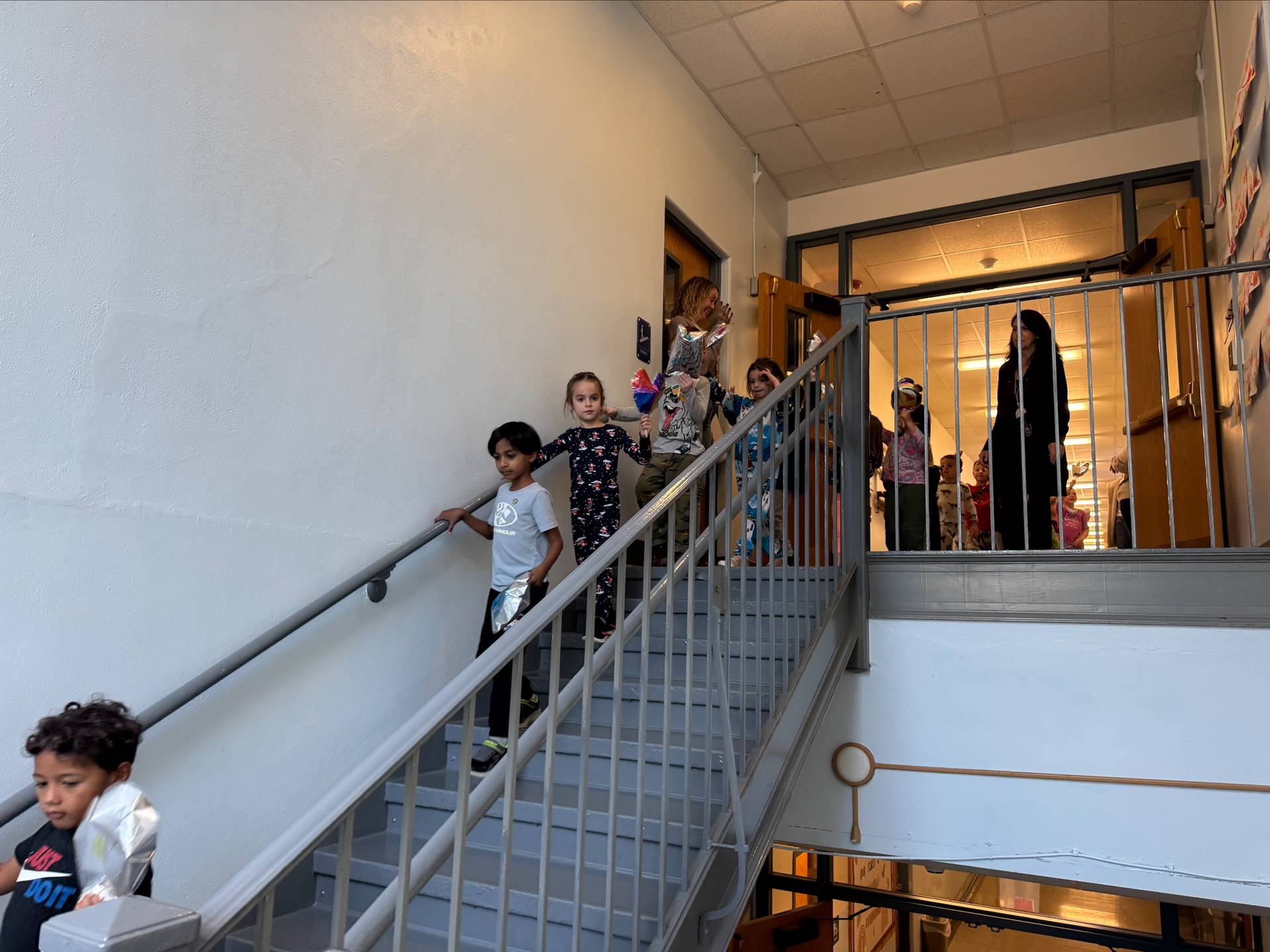 children reenacting a Macy's Day parade complete with balloons and walking downstairs