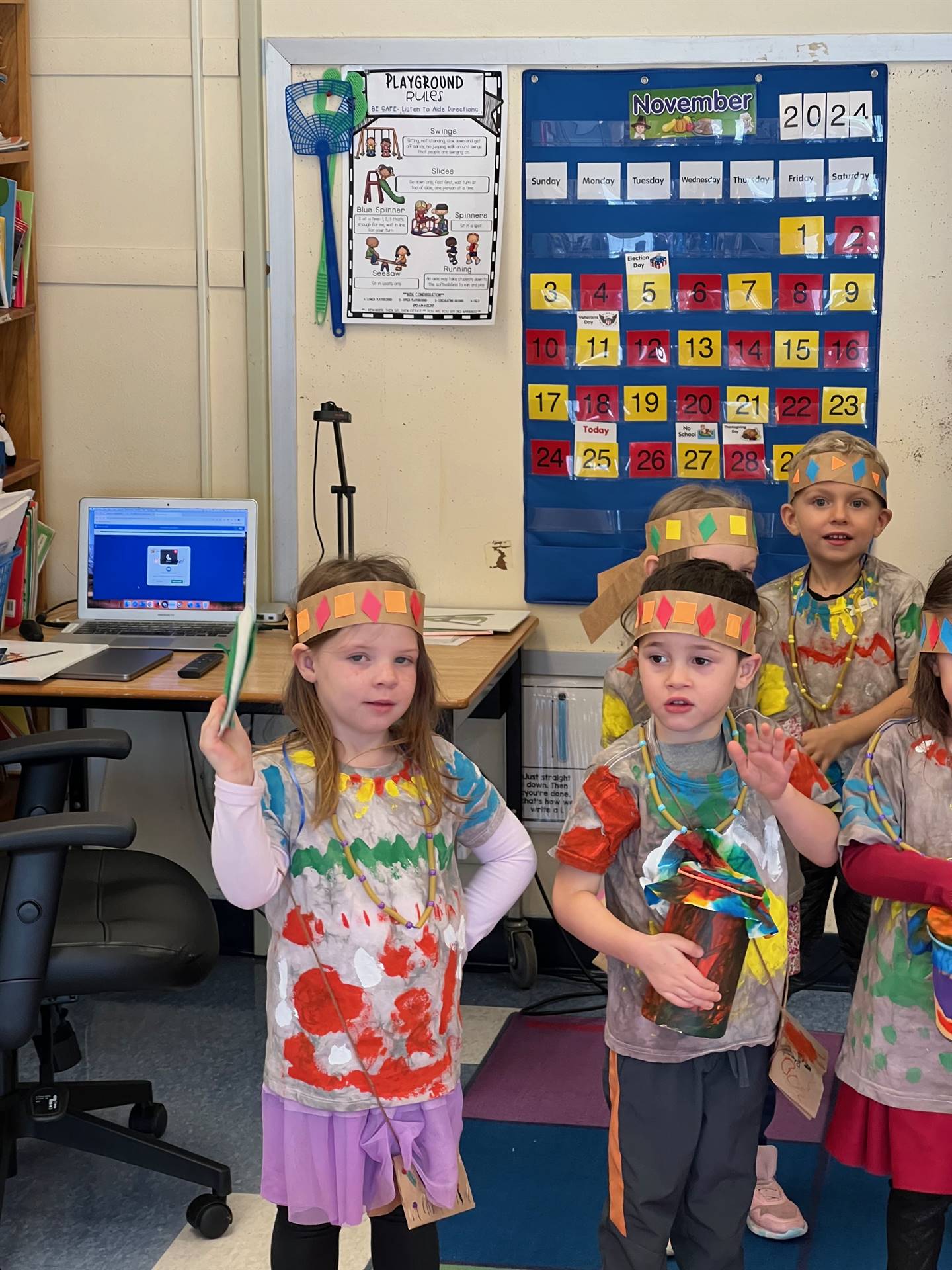 children dressed as native americans and beating on homemade drums.