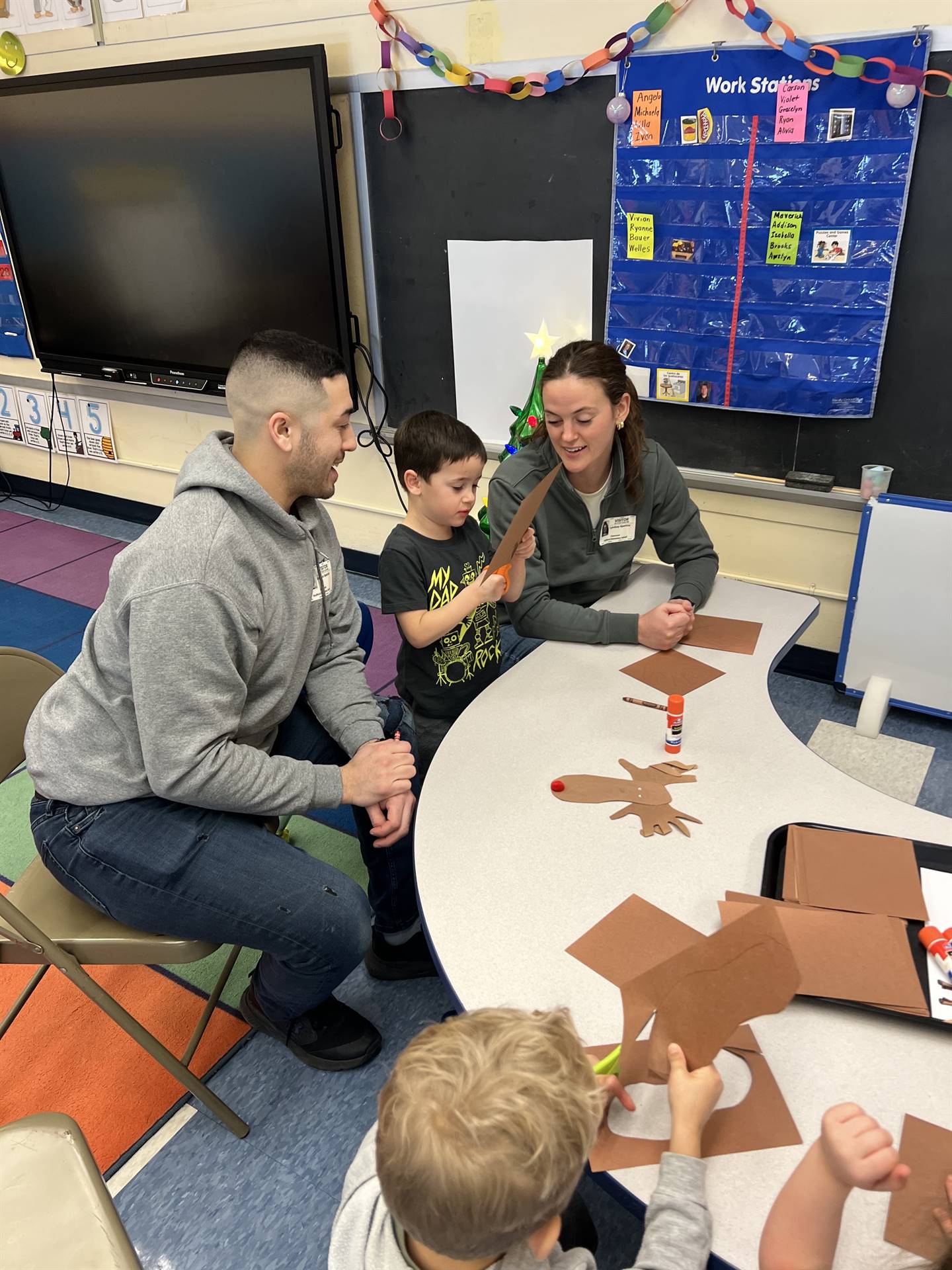 adults and students crafting together to make a reindeer.