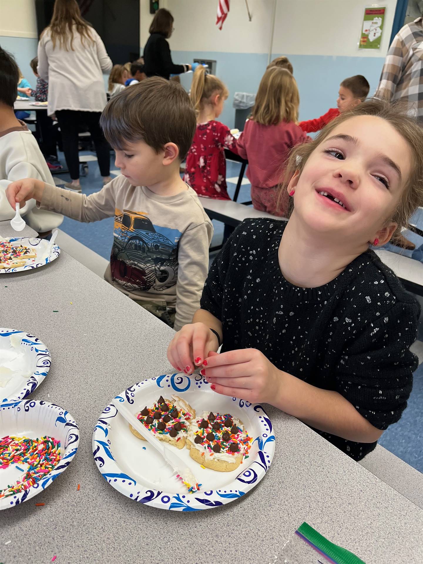 student decorating sugar cookie with icing and candy