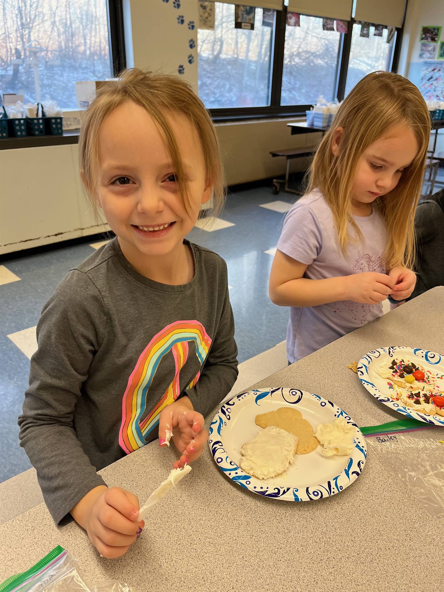 students decorating sugar cookie with icing and candy
