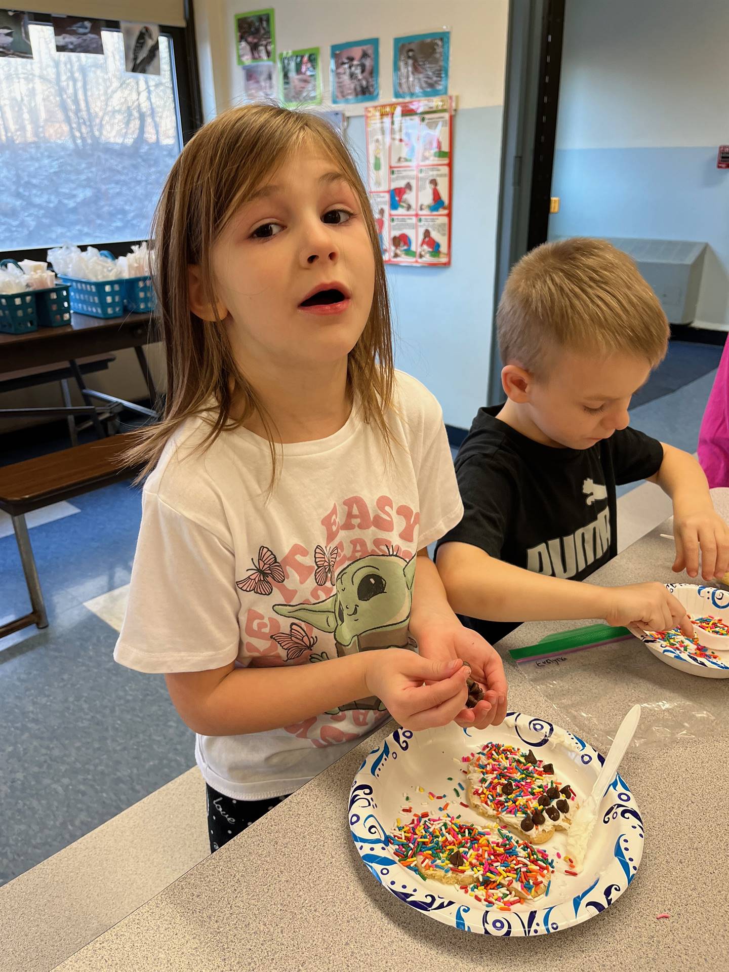 students decorating sugar cookie with icing and candy