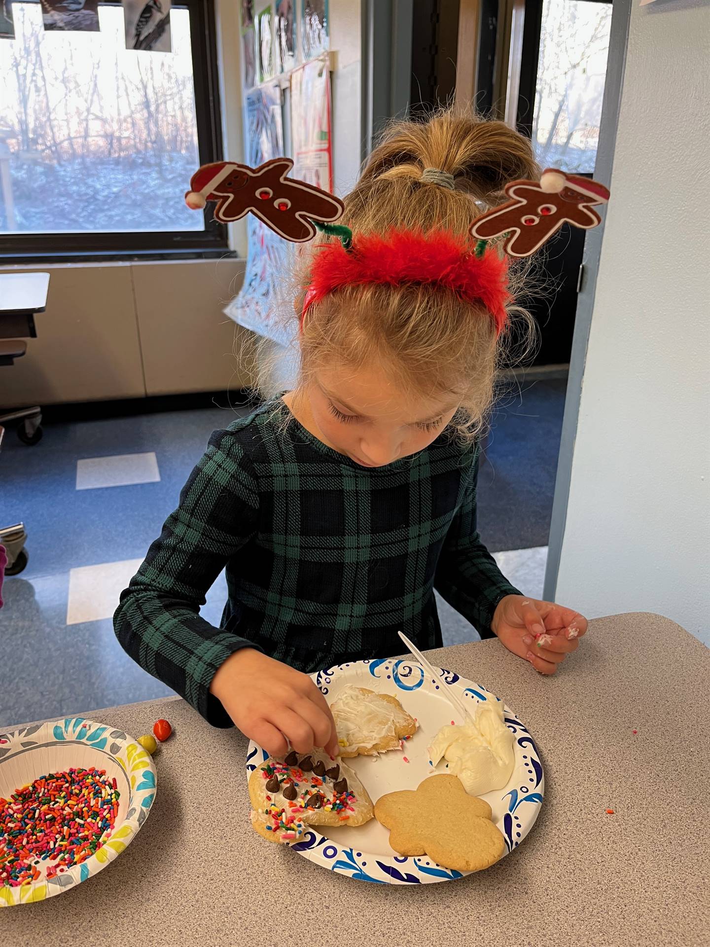 student decorating sugar cookie with icing and candy