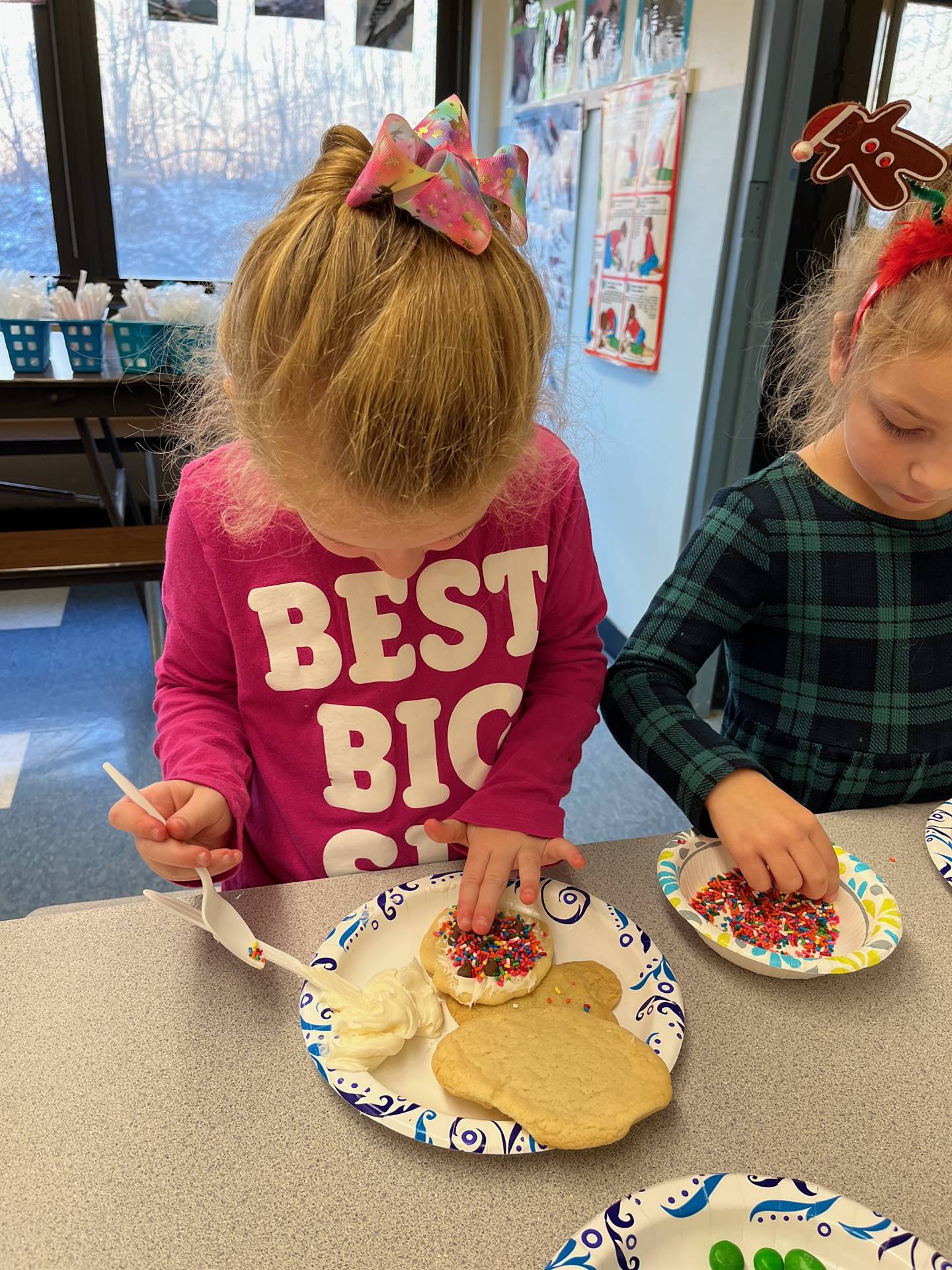 student decorating sugar cookie with icing and candy