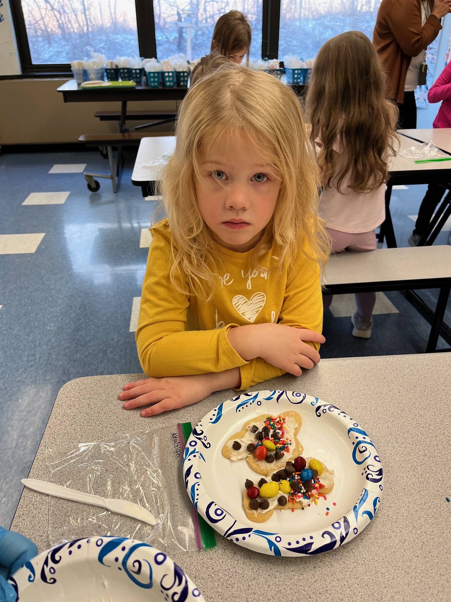 student decorating sugar cookie with icing and candy