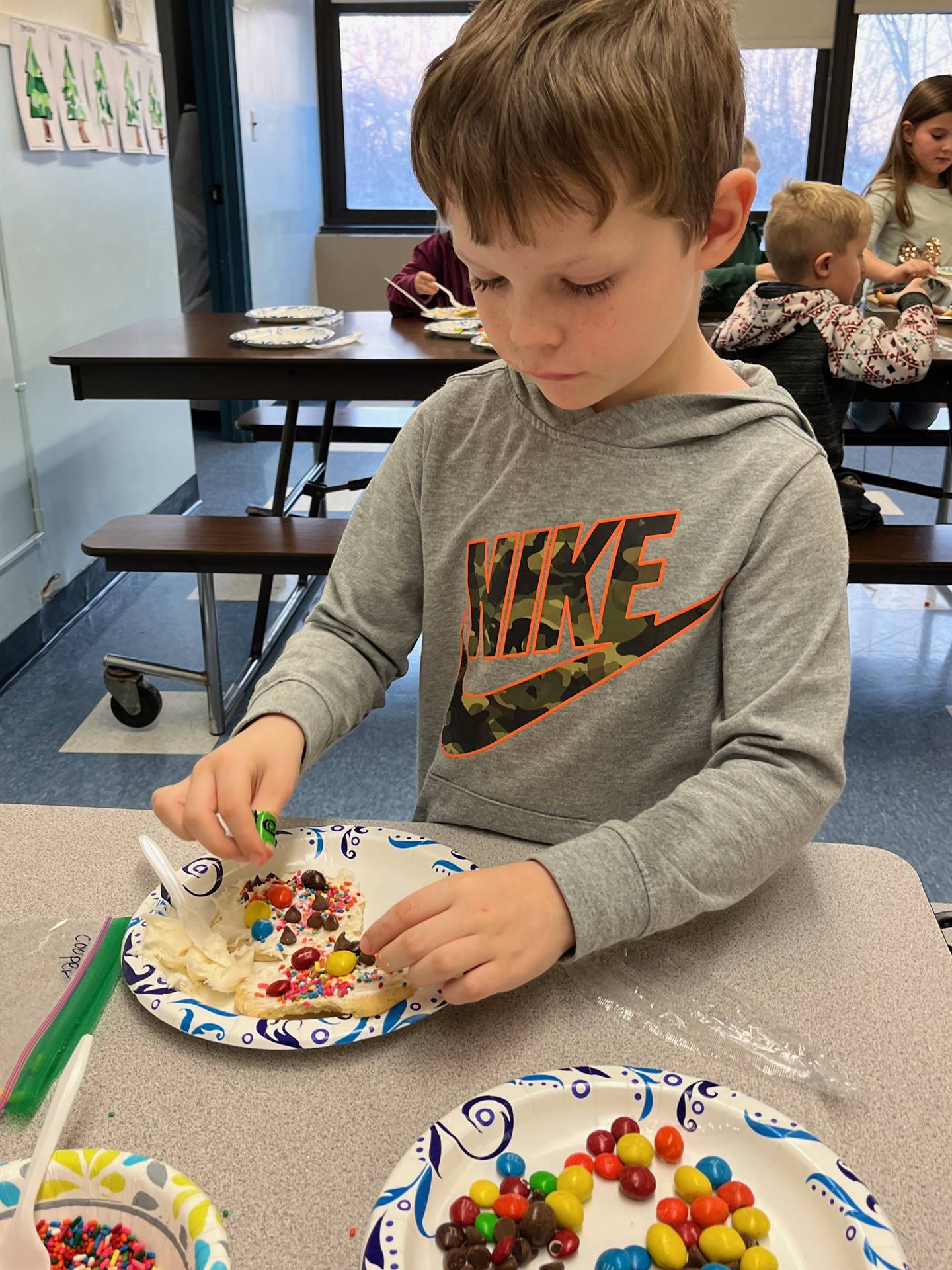 student decorating sugar cookie with icing and candy