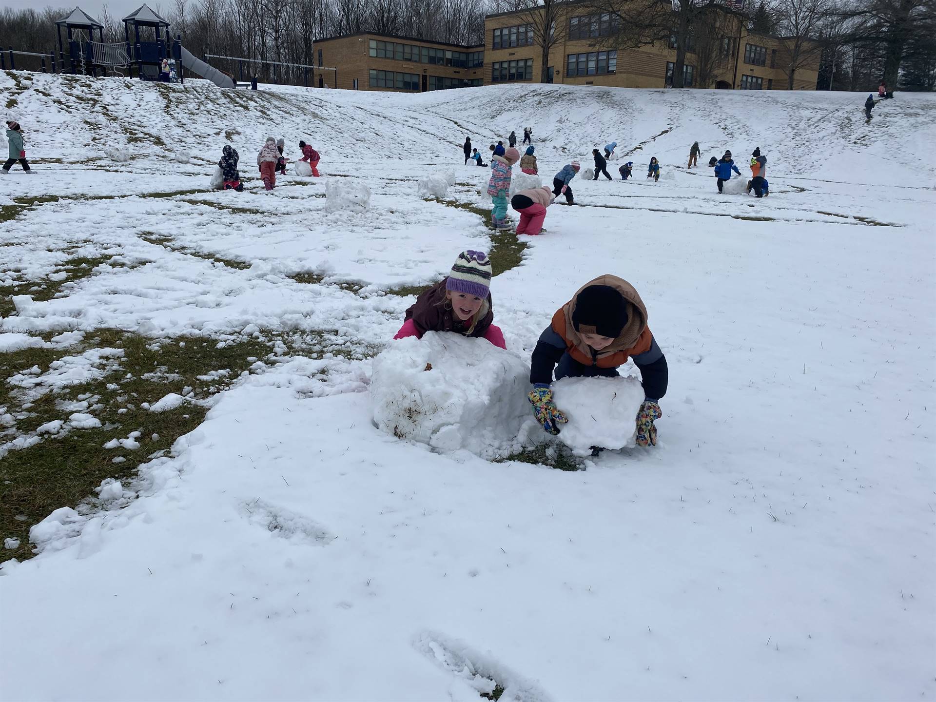 kids outside rolling snow into giant balls.