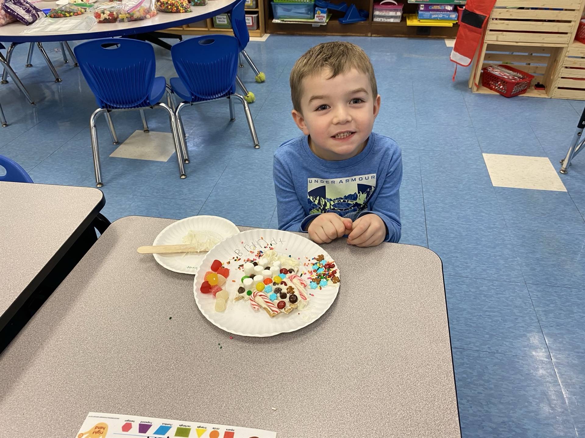 a student decorating a gingerbread house.