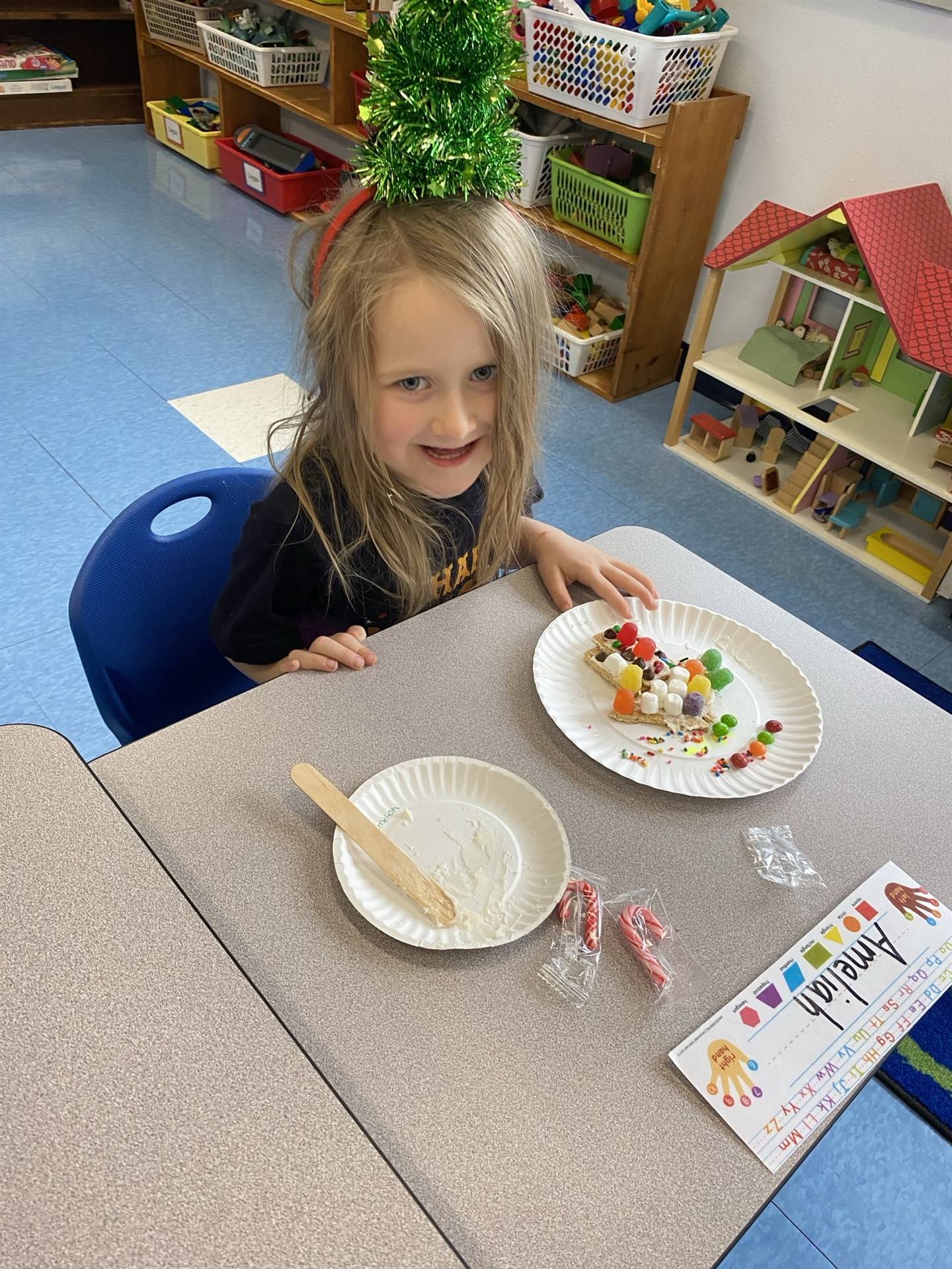 a student decorating a gingerbread house.