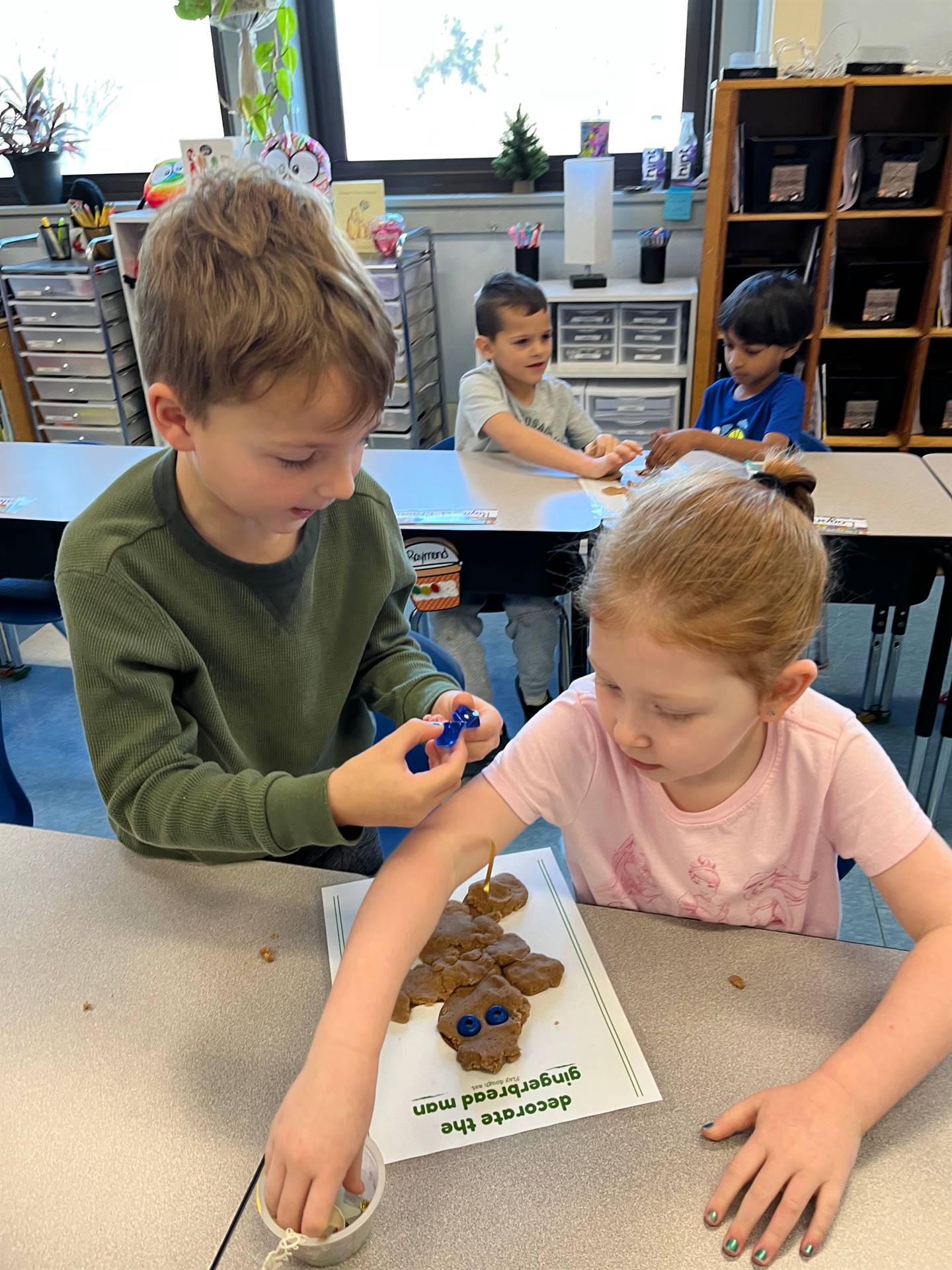 2 students working together to create a play do ginger bread friend.