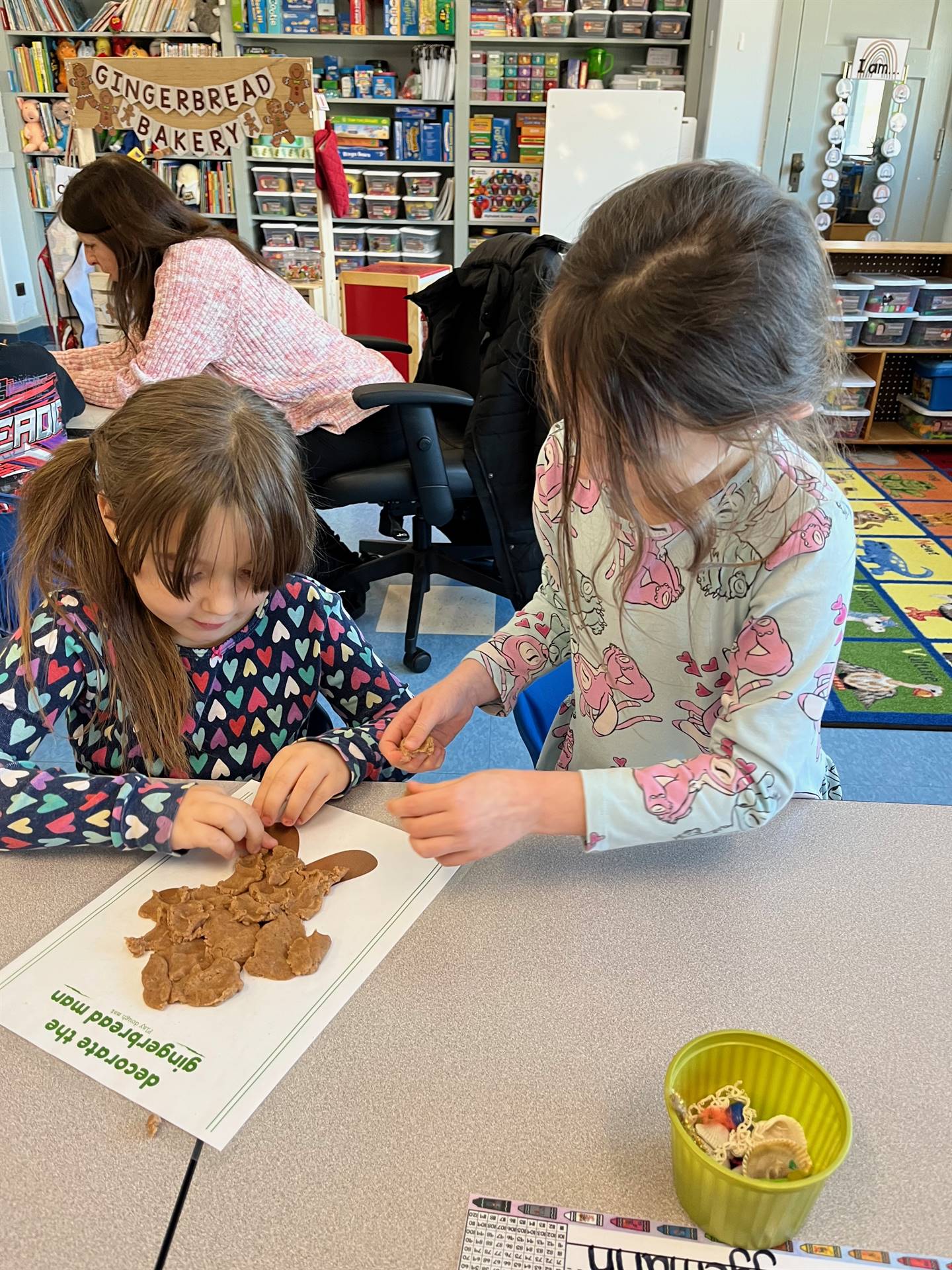 2 students working together to create a play do ginger bread friend.