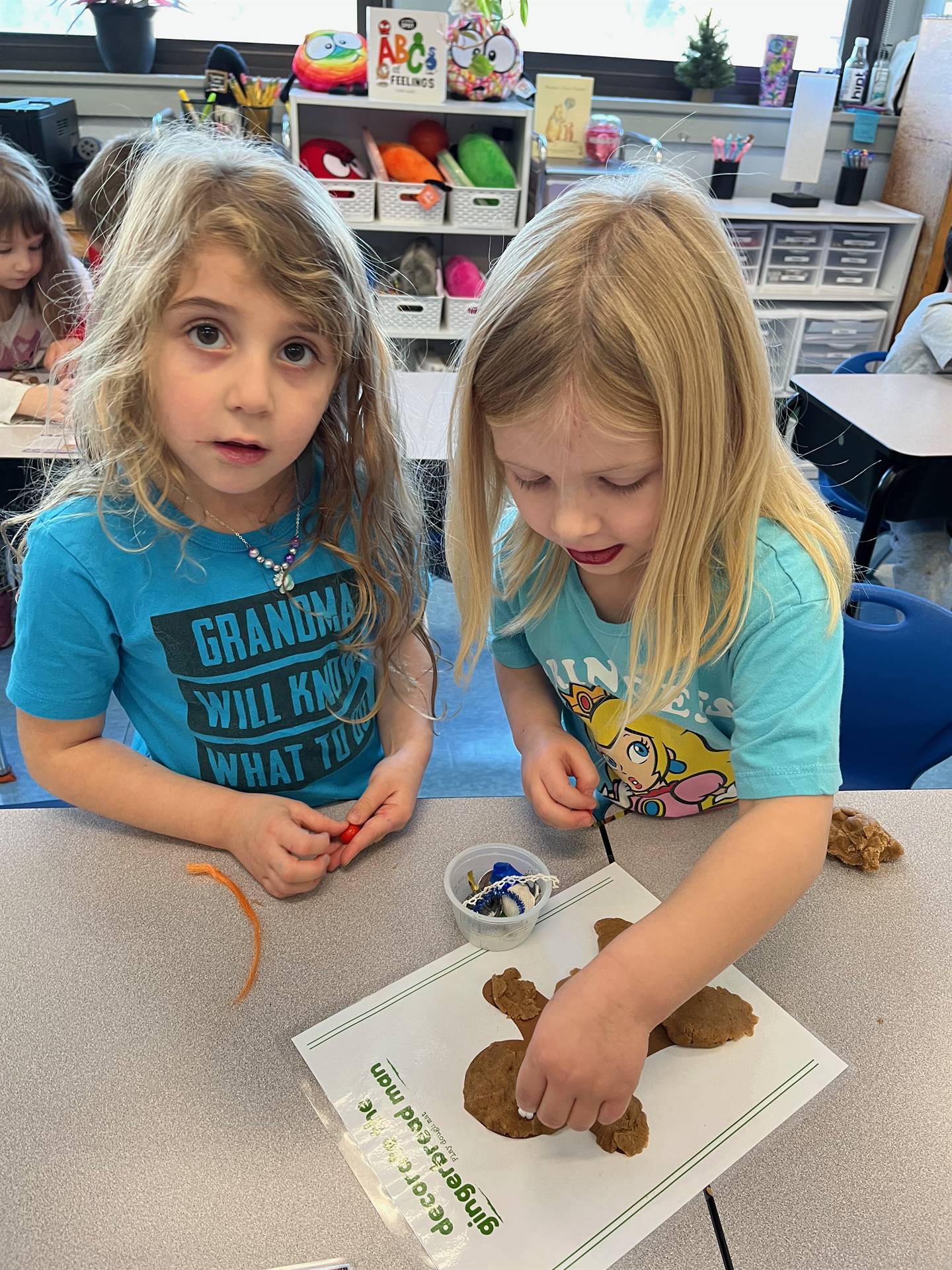 2 students working together to create a play do ginger bread friend.