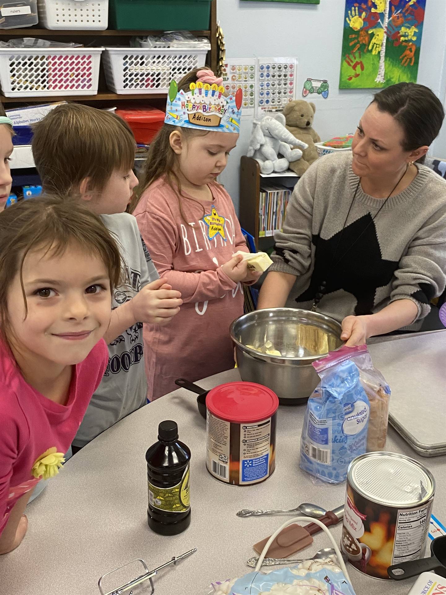 students with teacher mixing cookie ingredients.