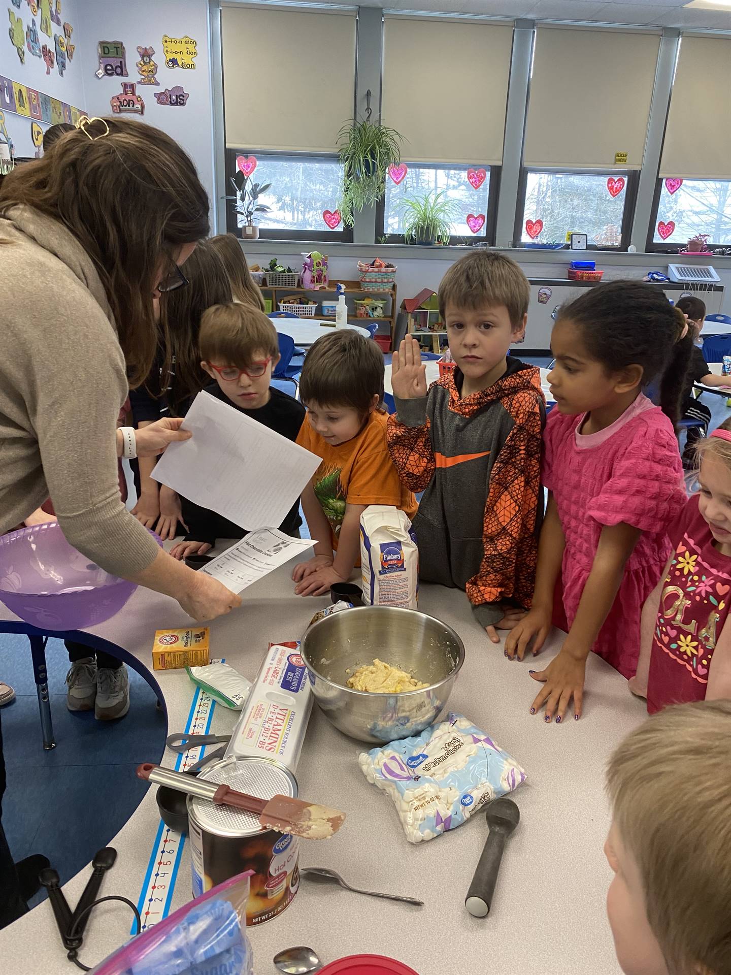 students with teacher mixing cookie ingredients.