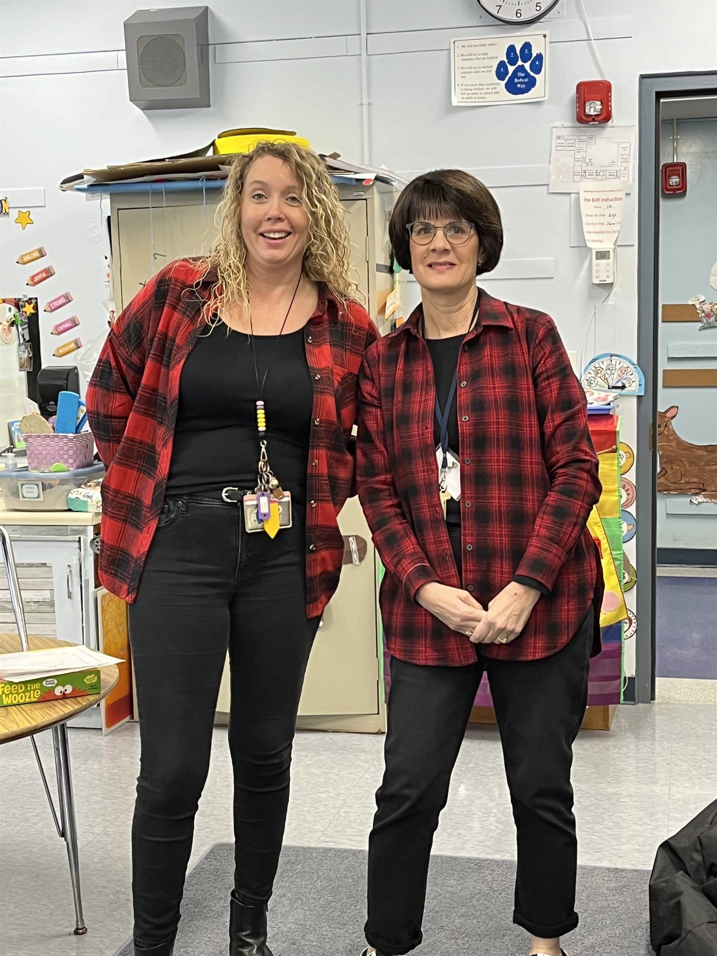 2 adults in matching black and red plaid shirts