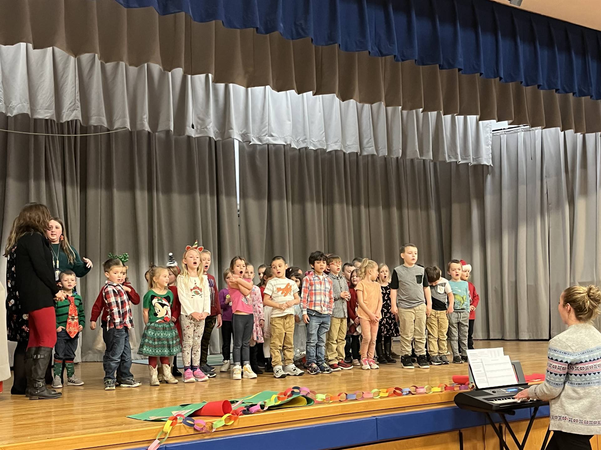 a large group of students on stage with gray curtain background